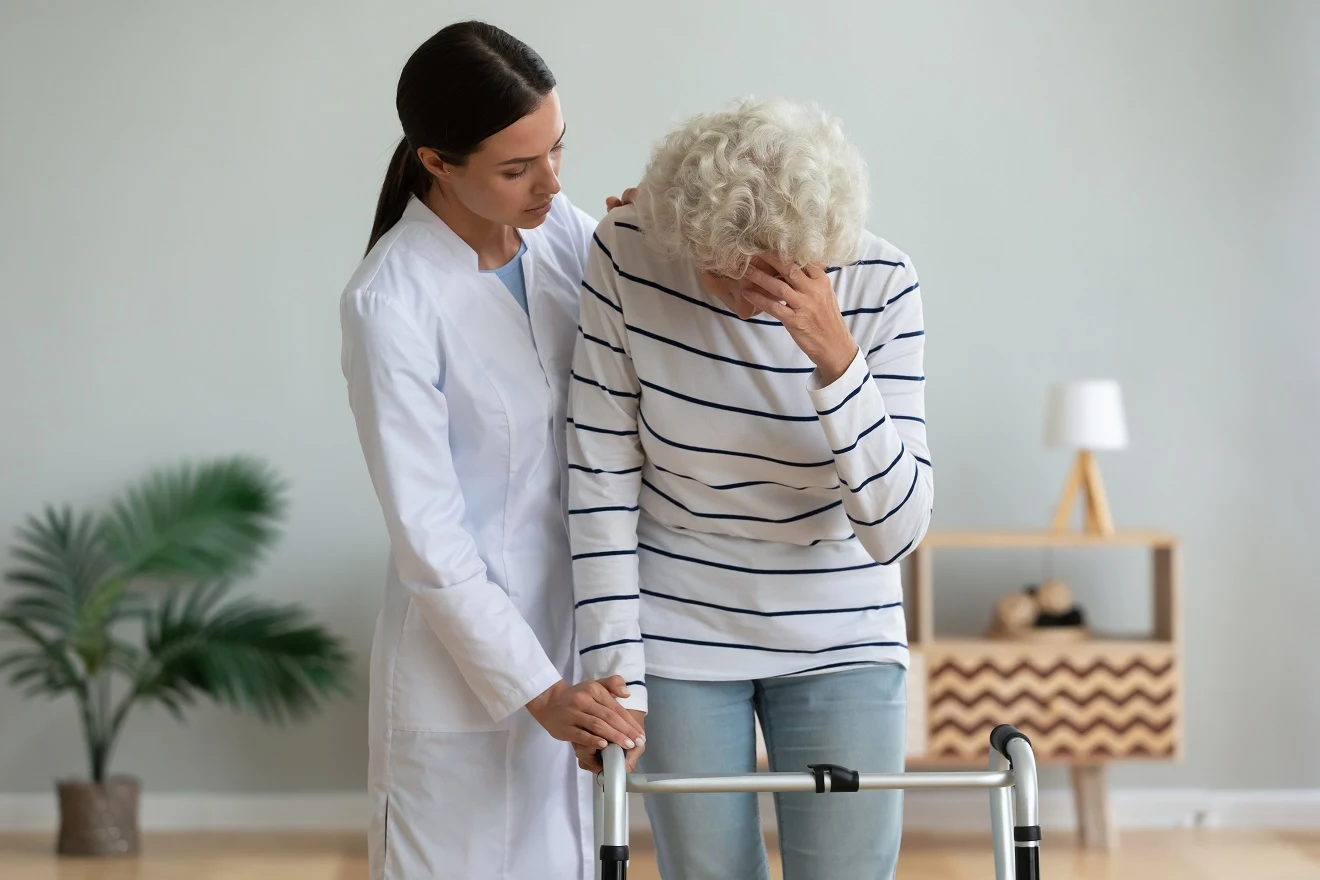 Physical therapist assisting an older adult with balance during vestibular rehabilitation