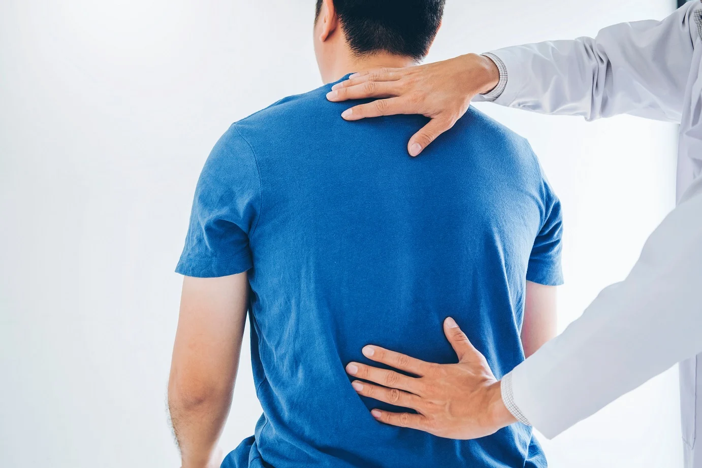 Physical therapist examining a patient's lower back