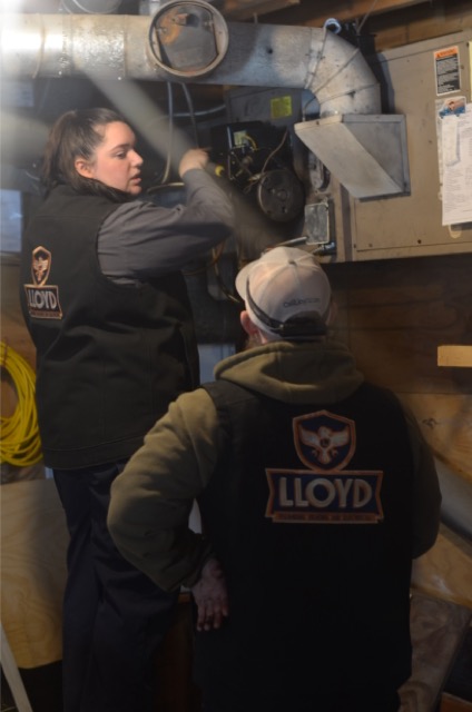 Lloyd Plumbing, Heating, Air, Electrical shows hands-on expertise and teamwork while inspecting a home HVAC system for reliable performance.