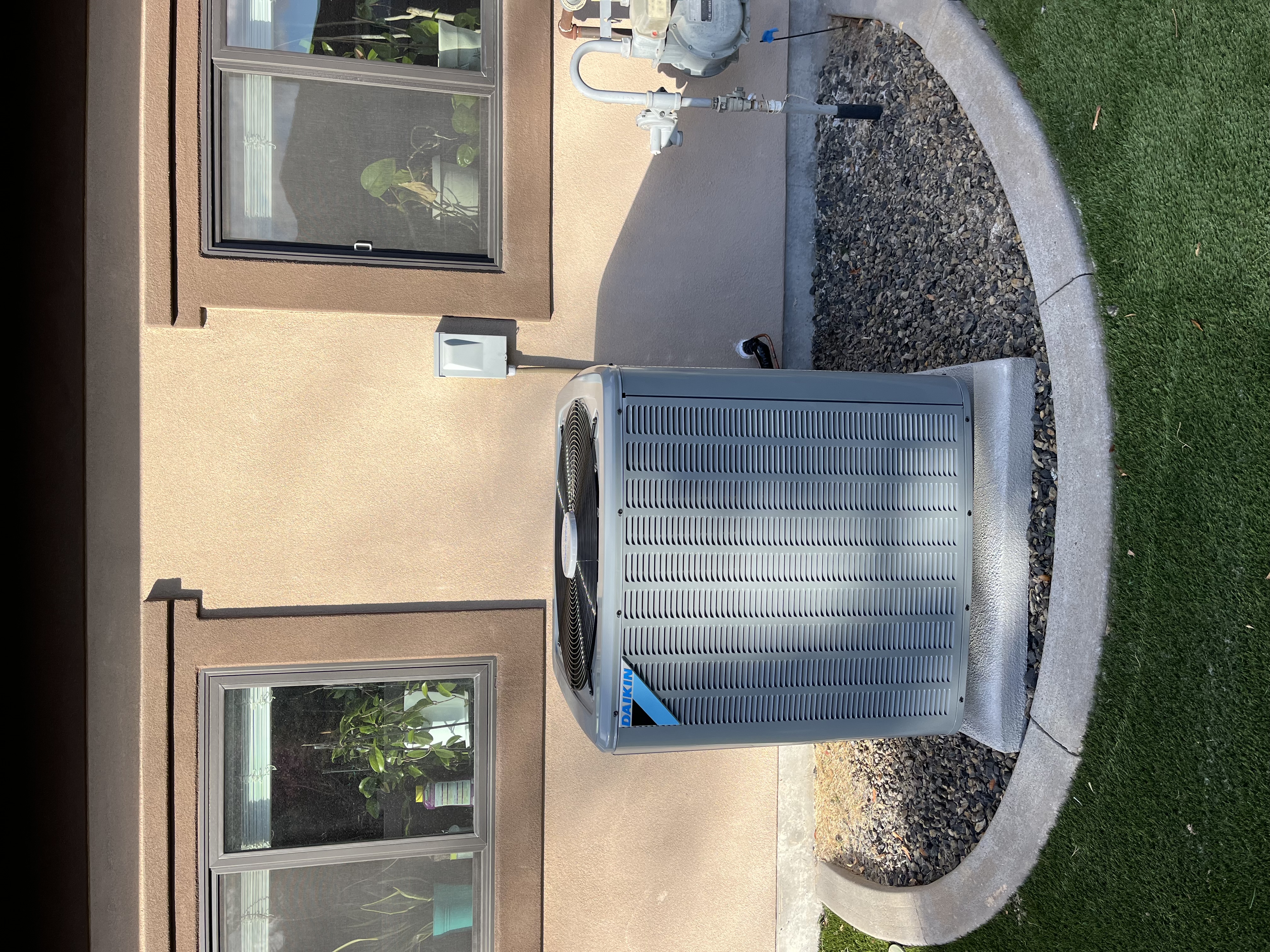 A clean Daikin outdoor unit installed on a tidy pad shows Home Heating & Air Conditioning's commitment to reliable, professional service.