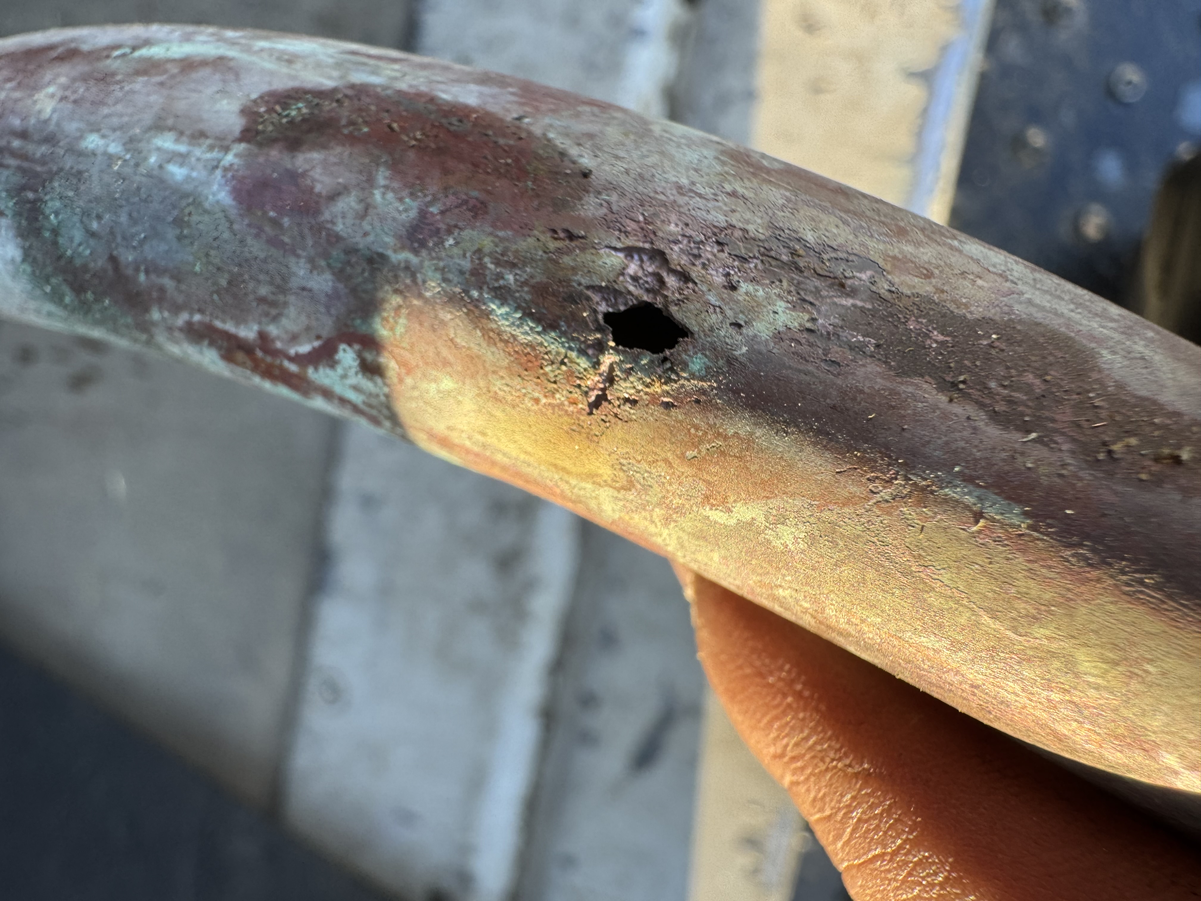 This close inspection shows a corroded copper line that needed replacement, trust Cruz Plumbing & Rooter Services for reliable pipe repair.