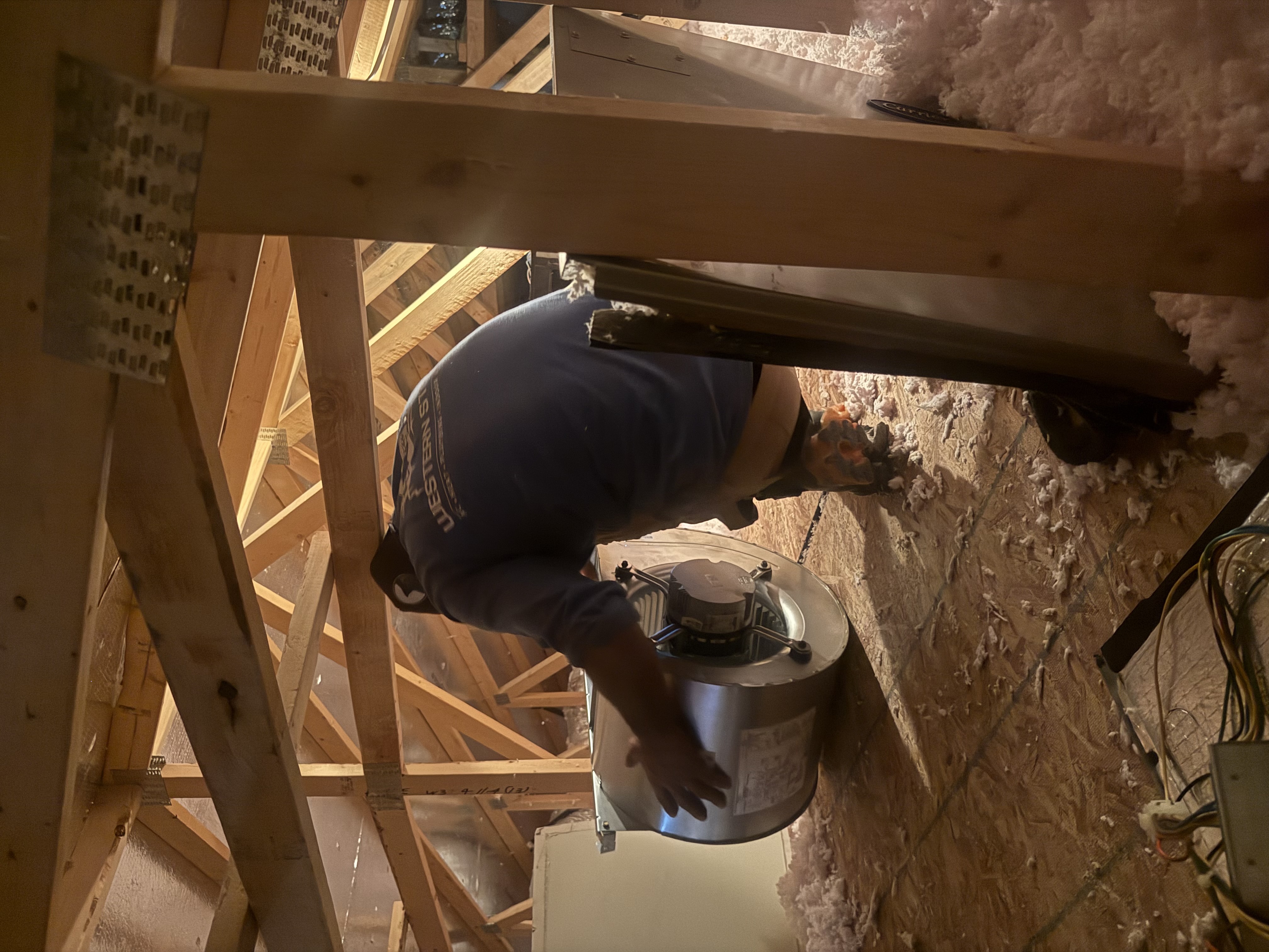A skilled technician from Western States Home Services carefully installs attic HVAC components to ensure reliable performance and lasting comfort.