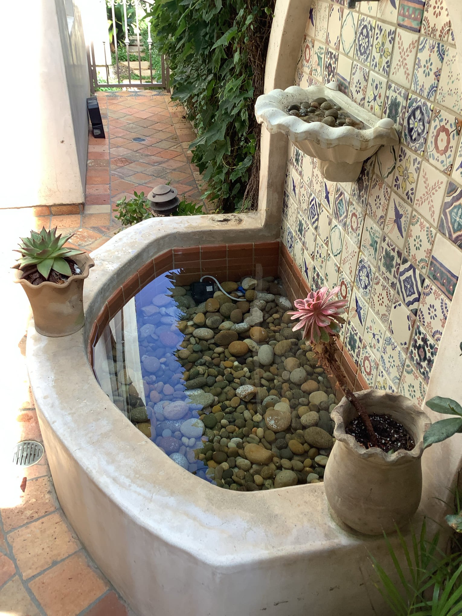A tranquil tiled fountain and stone-filled basin showcase Powell Electric's commitment to dependable, thoughtfully finished outdoor solutions.