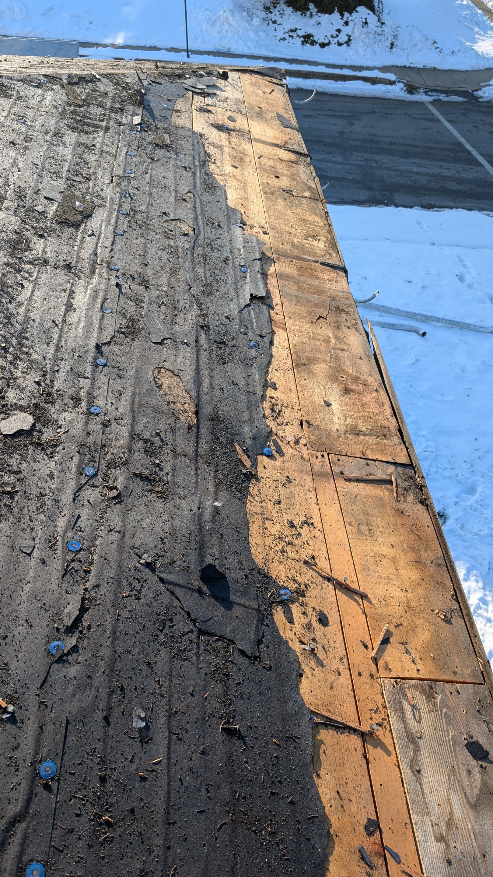 Showing careful roof replacement progress, Mosaic Roofing & Exteriors exposes old underlayment and prepares decking for a durable new installation.