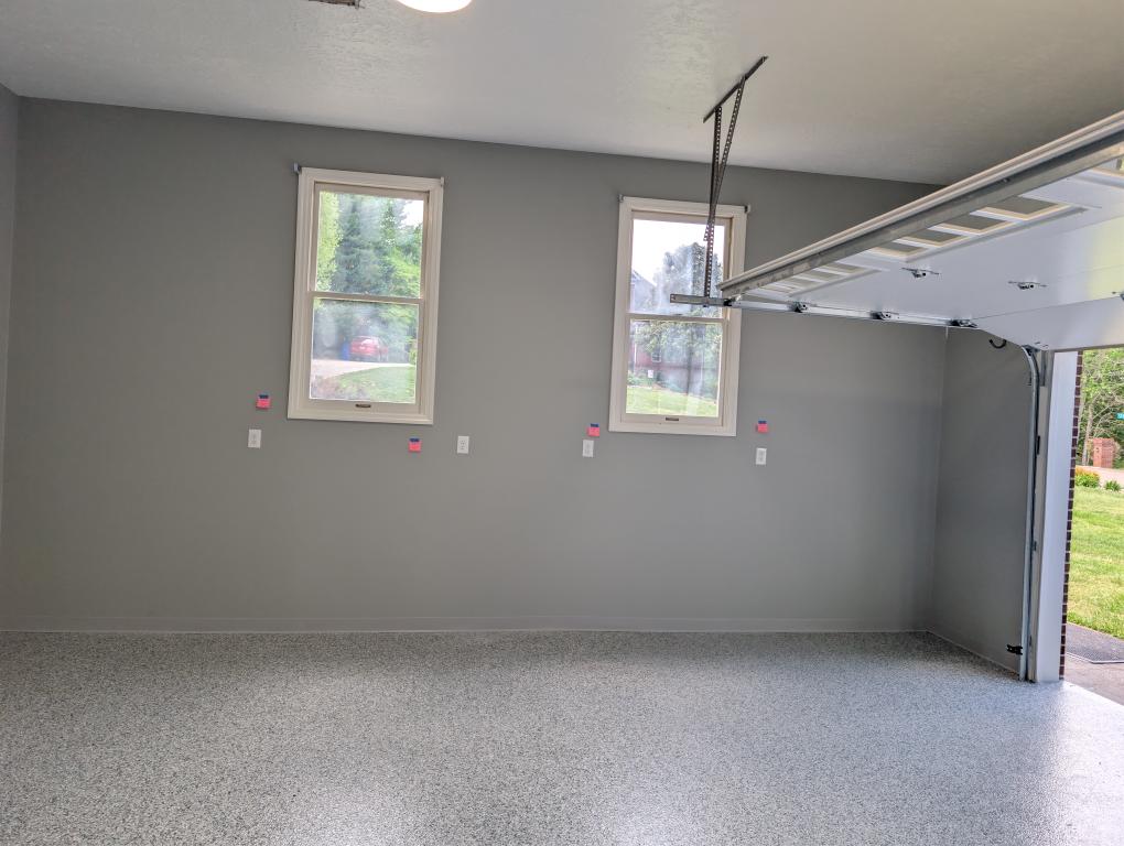 A clean, professionally finished garage with organized outlets and durable flooring showcases Atomic Electric Service Inc.'s commitment to quality and safety.