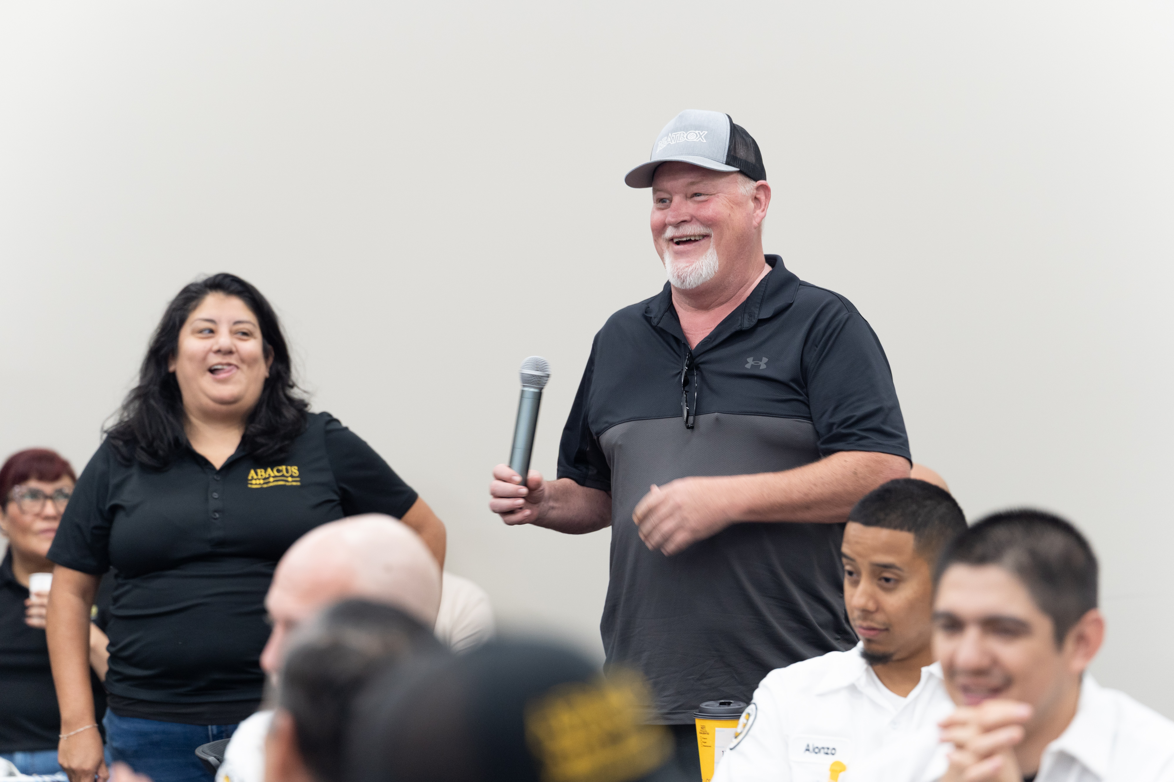 Smiling team members share knowledge and build trust in a training session led by Abacus Plumbing, Air Conditioning, & Electrical.