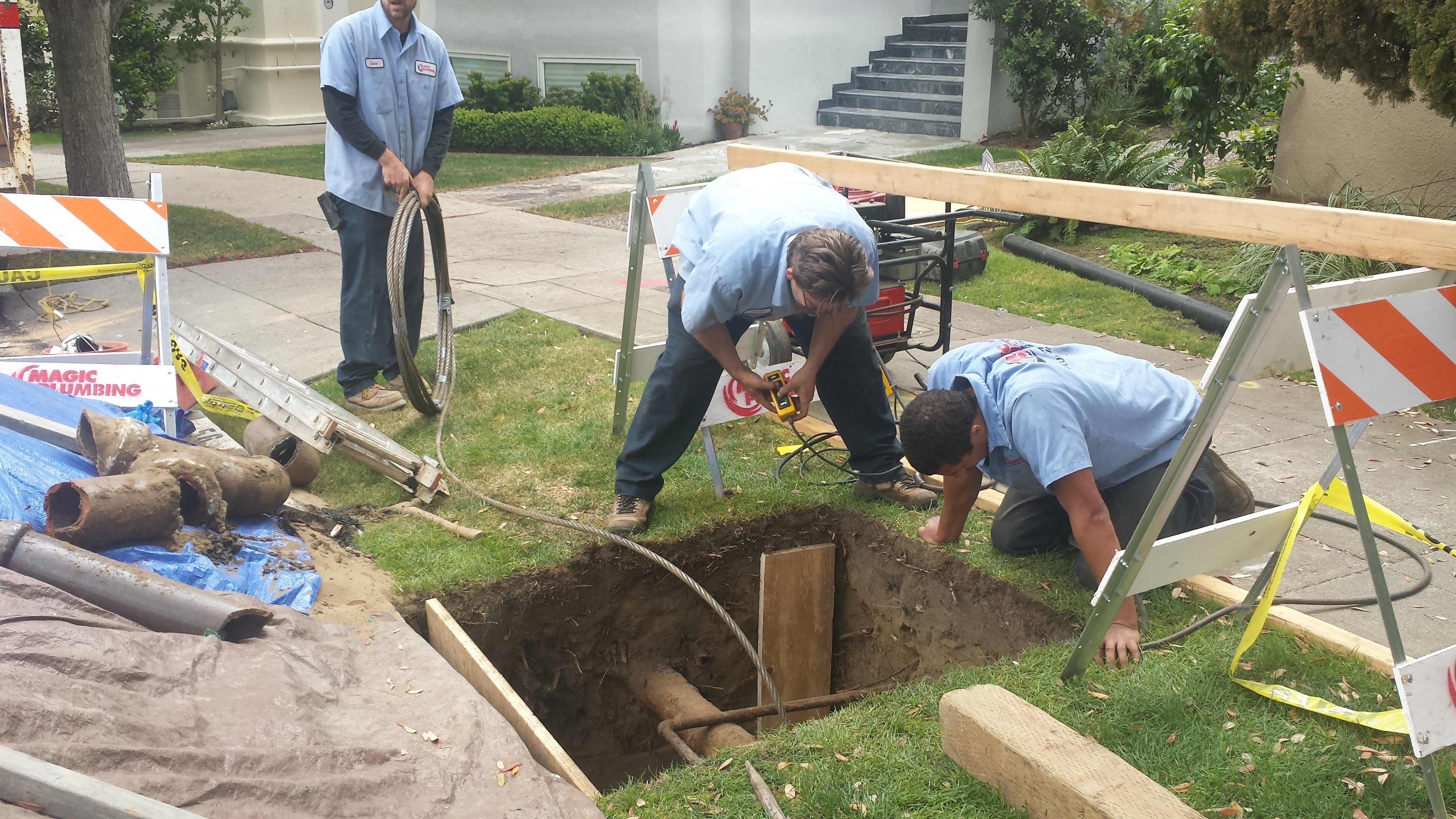 A skilled Magic Plumbing Heating & Cooling crew performs careful trench and pipe work at a home, demonstrating dependable craftsmanship and safety.