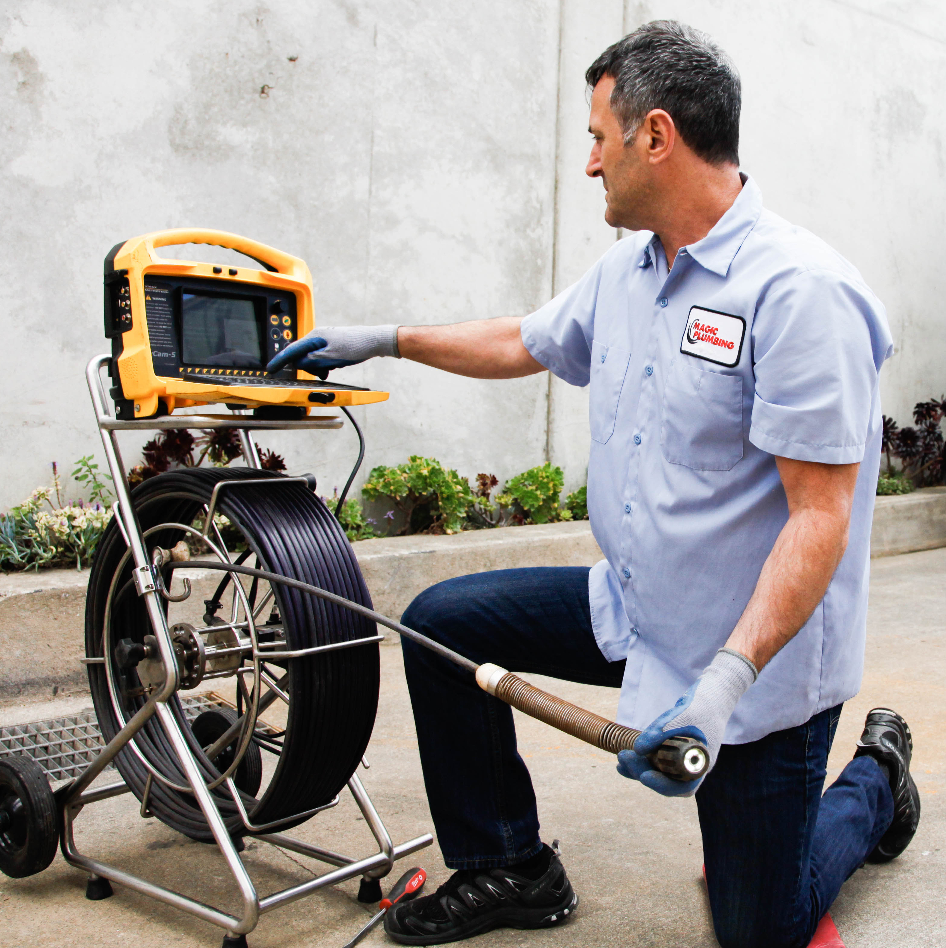 A skilled technician from Magic Plumbing Heating & Cooling performs a precise drain camera inspection, showing clear results and dependable service.