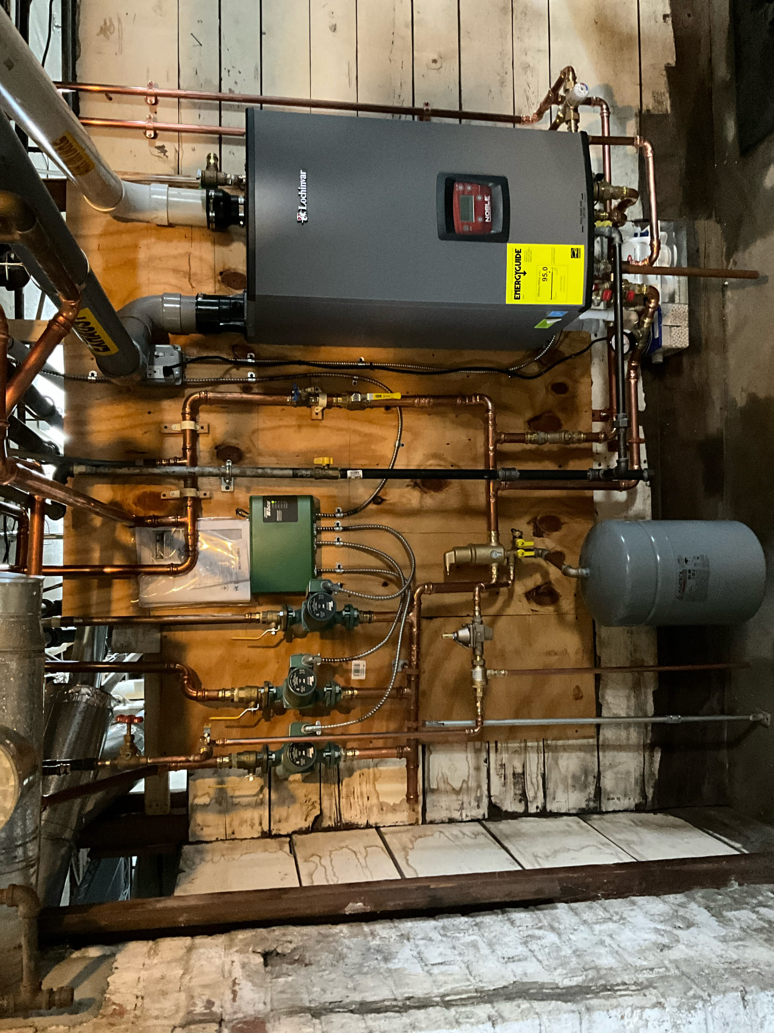 Expert installation and tidy workmanship ensure reliable home comfort from Akian Plumbing, Heating, Cooling & Electric, featuring an efficient Lochinvar boiler.
