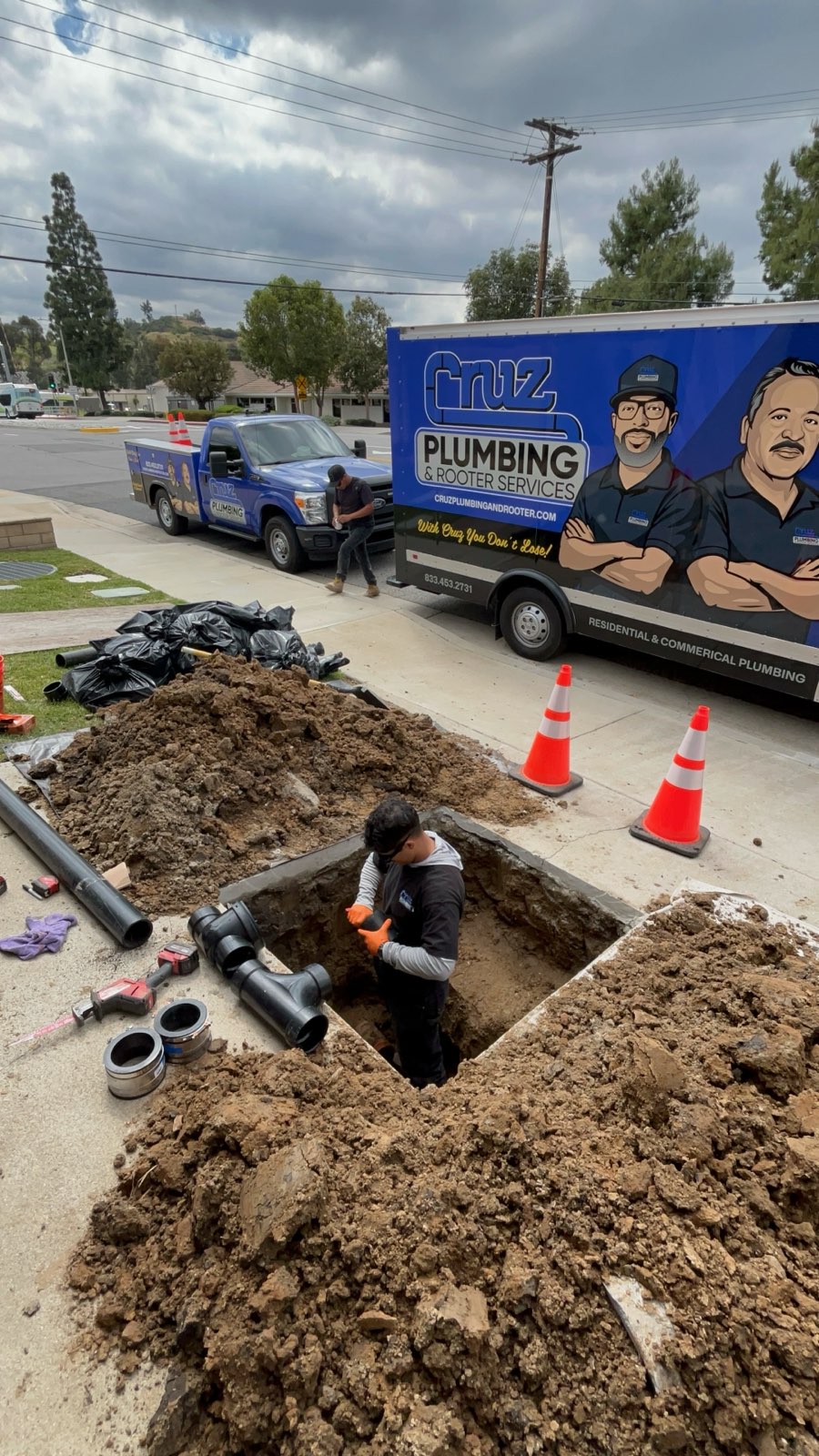 Cruz Plumbing & Rooter Services shows reliable on-site craftsmanship and safety while completing a durable sewer repair for local homeowners.