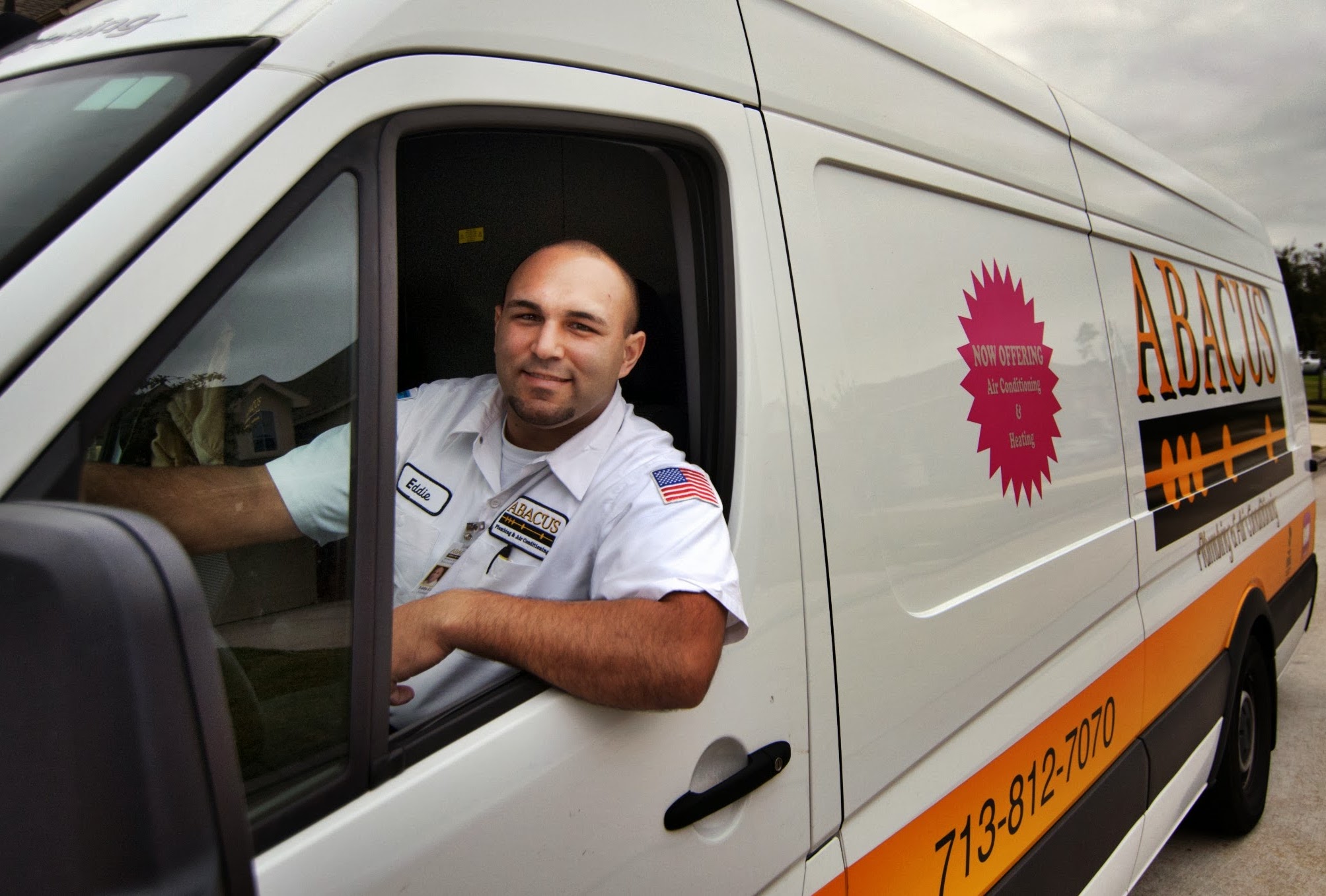 A friendly, uniformed technician arriving in a clearly branded van shows Abacus Plumbing, Air Conditioning & Electrical delivers professional, customer-focused service.