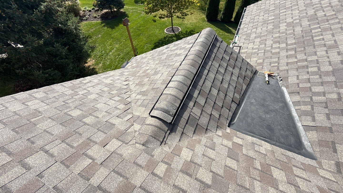 Expert craftsmanship on a residential roof shows durable ridge ventilation and tidy flashing, demonstrating Mosaic Roofing & Exteriors' reliable results.