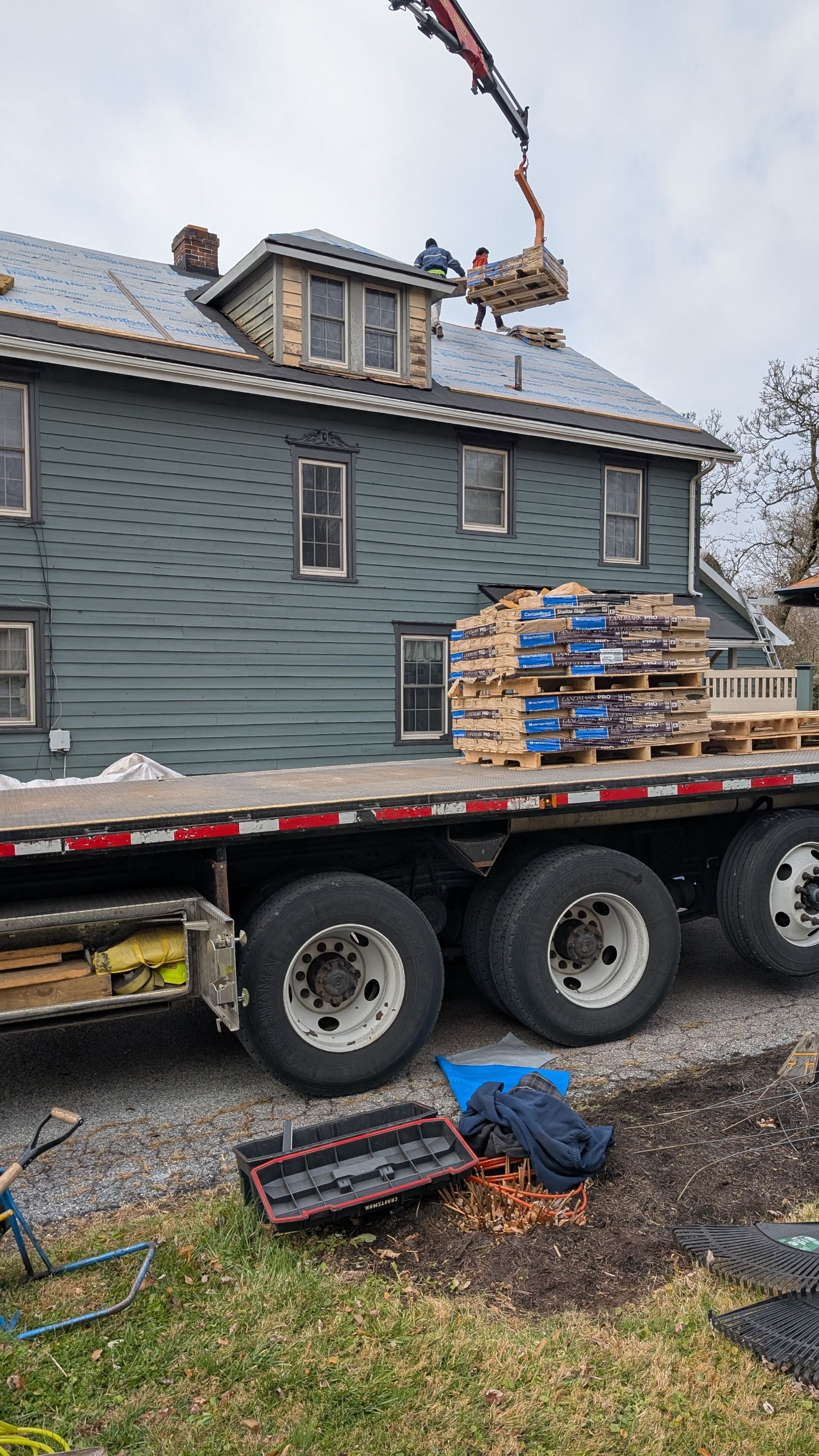 Skilled crews from Mosaic Roofing & Exteriors deliver efficient, safe roof replacement work using staged materials and crane-assisted lifts.
