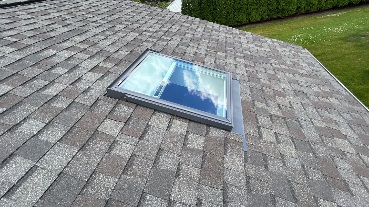 A spotless skylight installation on a durable shingled roof shows the craftsmanship homeowners trust from Mast Roofing & Construction.