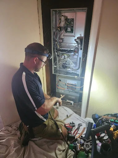 A skilled technician from AccuTemp Heating & Air Conditioning performs careful on-site furnace service, ensuring reliable comfort and peace of mind.