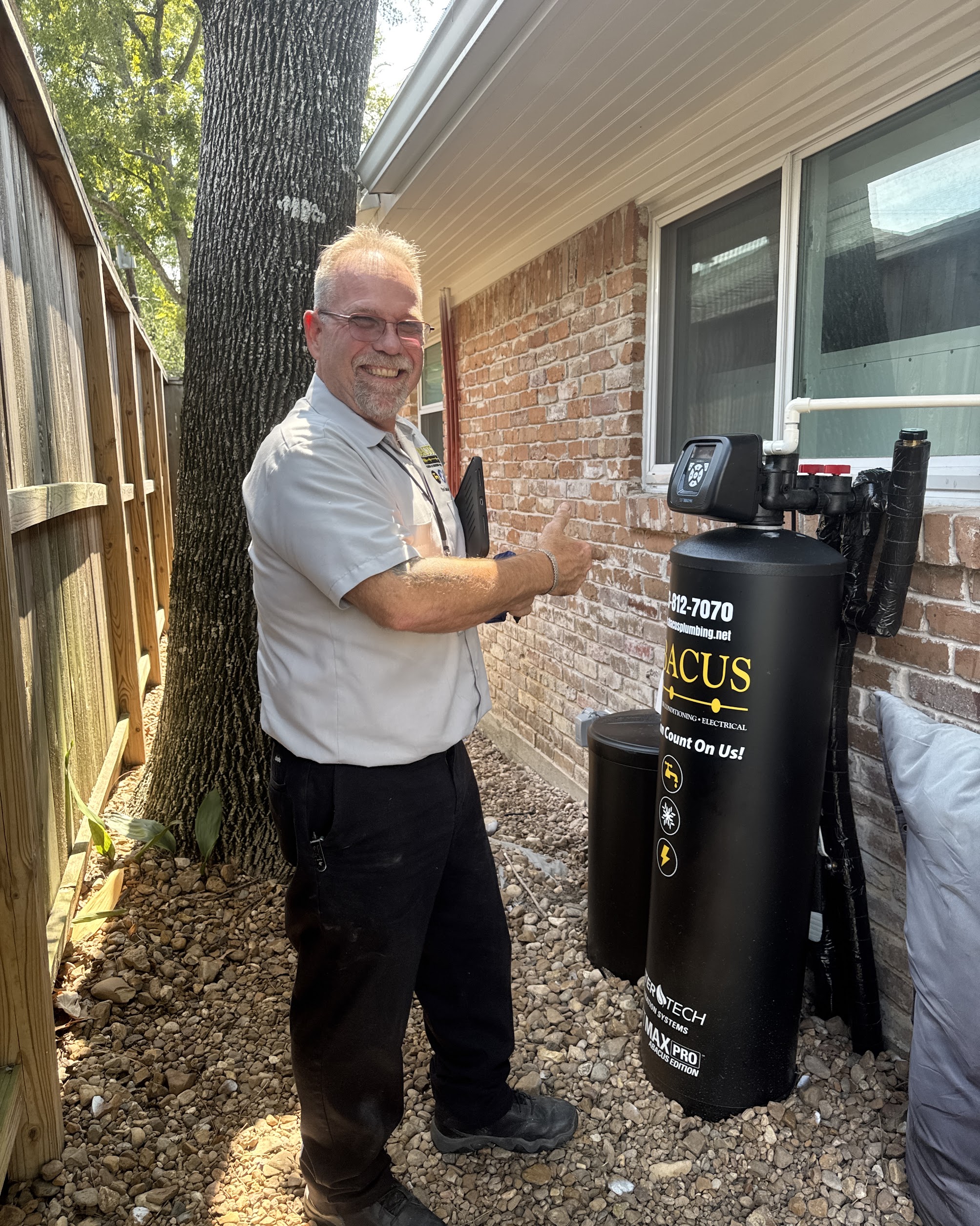 A friendly Abacus Plumbing, Air Conditioning & Electrical technician confirms reliable water treatment installation with pride, showing quality and care.