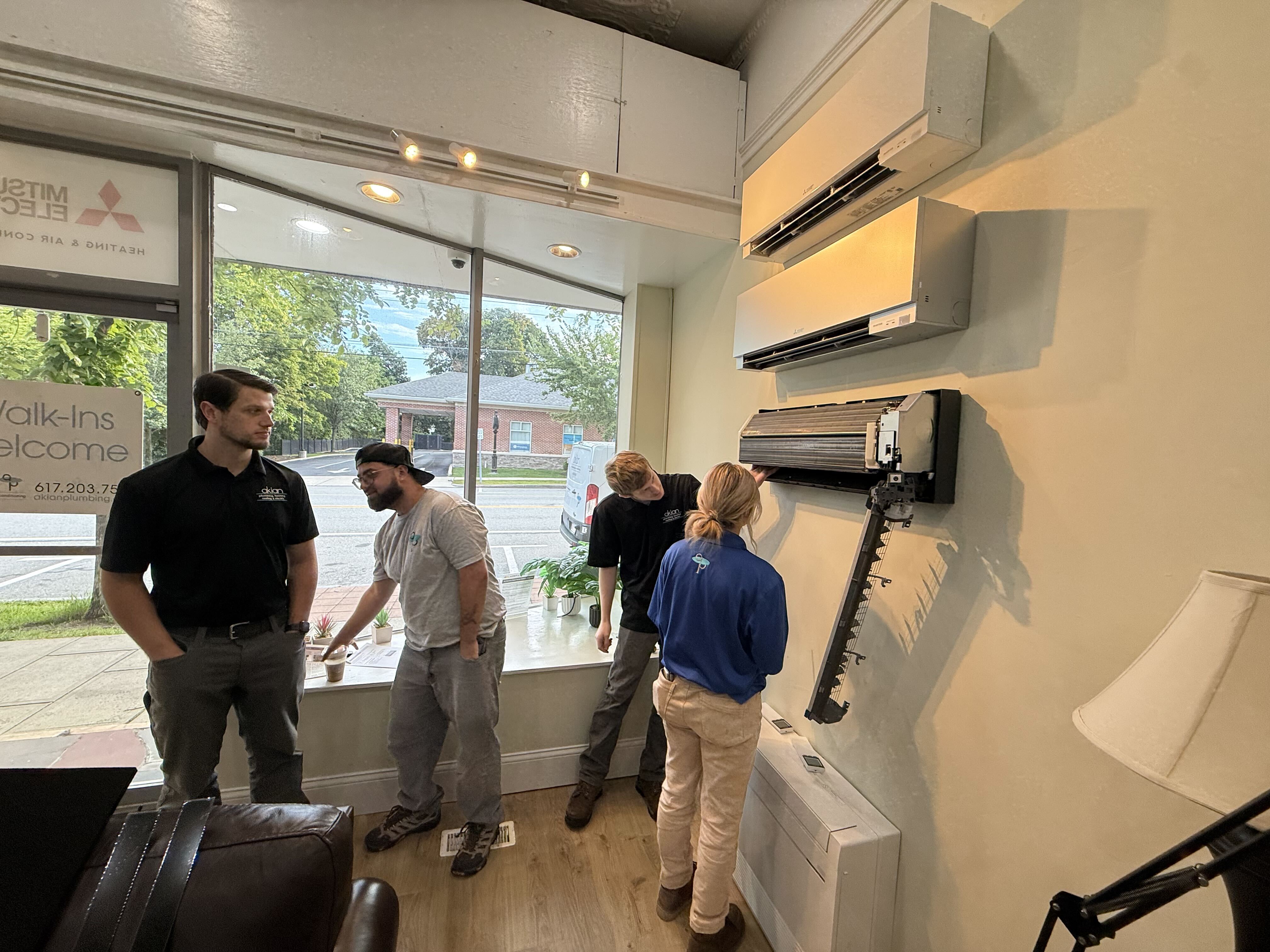 Friendly, professional technicians from Akian Plumbing, Heating, Cooling & Electric demonstrate careful ductless AC servicing to ensure reliable home comfort.