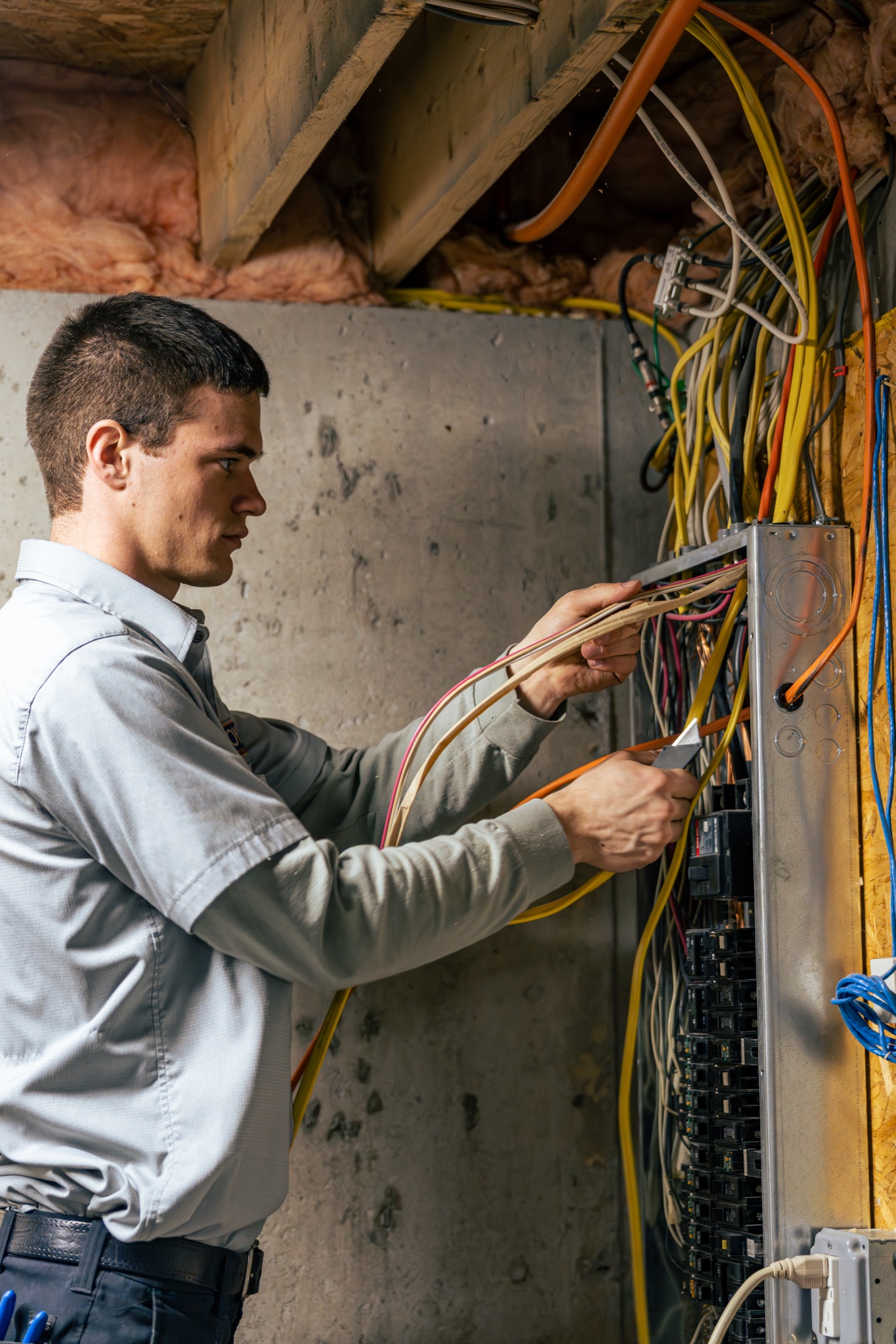 Focused craftsmanship on complex home electrical work highlights the reliability and expertise of Lloyd Plumbing, Heating, Air, Electrical.