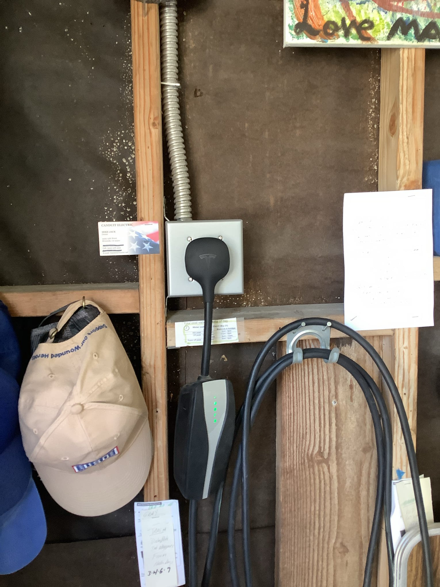 Powell Electric professionally installed this clean EV charging station in a garage, showing careful wiring and neat cable management.