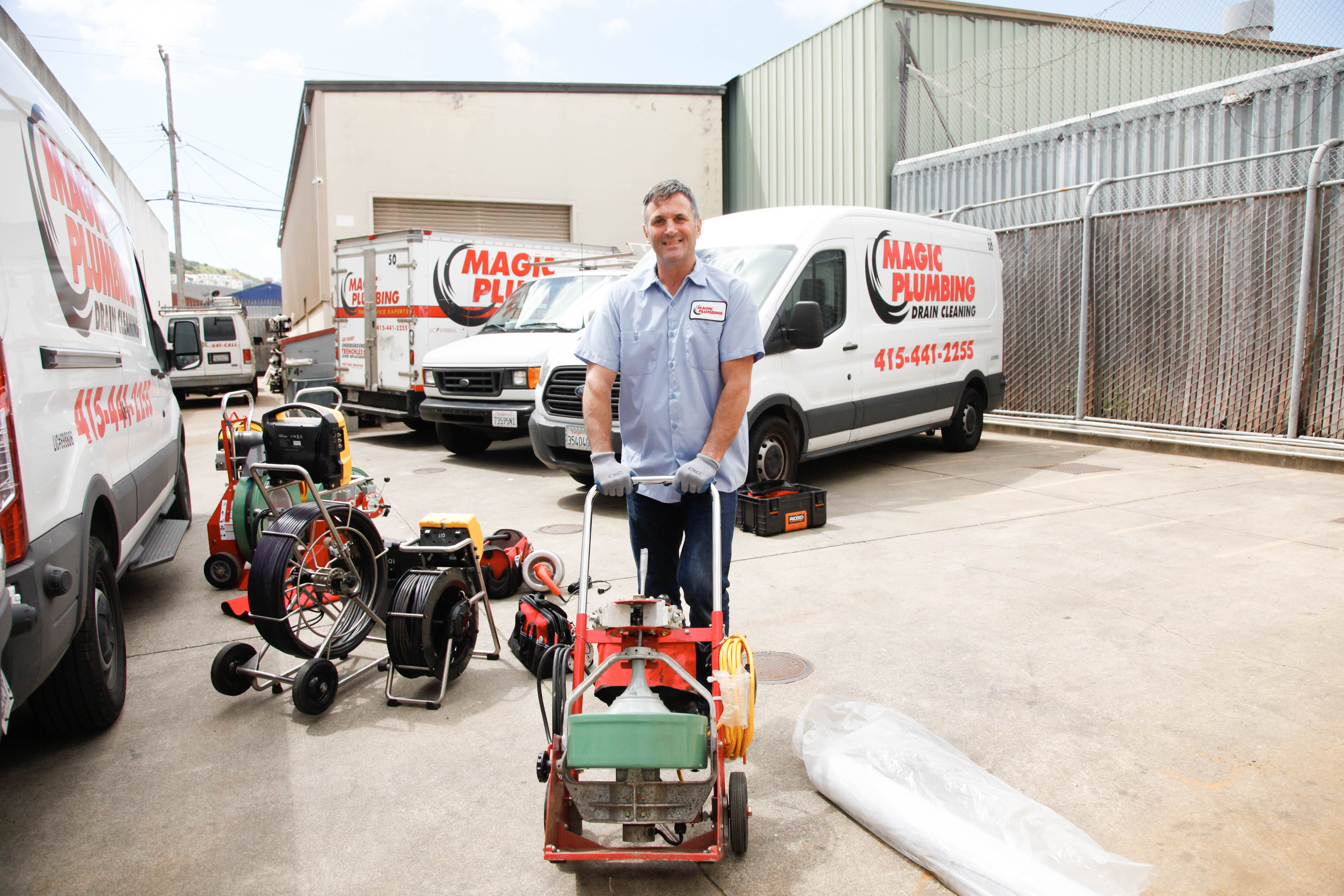 A friendly, professional technician from Magic Plumbing Heating & Cooling showcases organized drain equipment, demonstrating reliable service and craftsmanship.