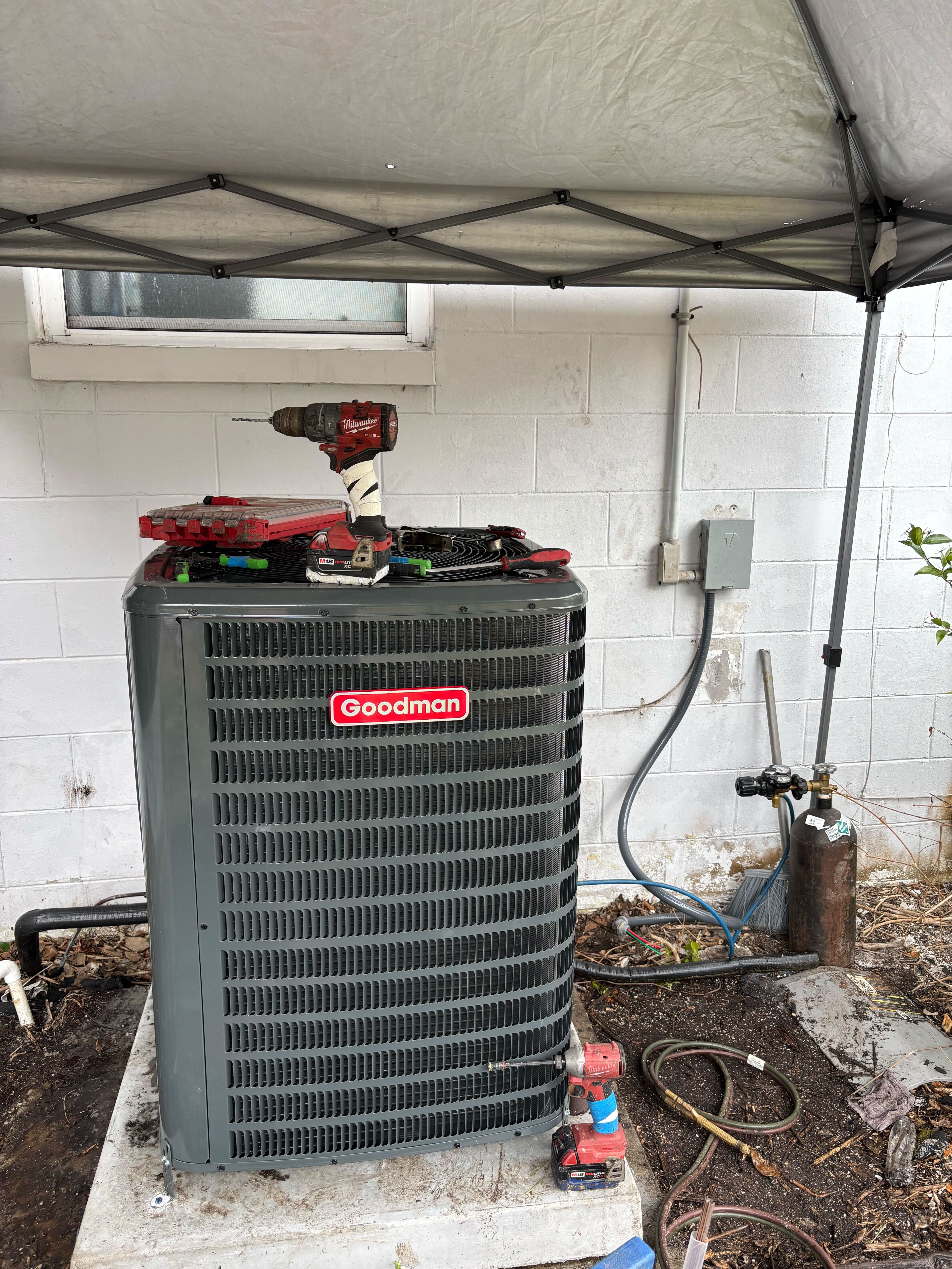 Quality HVAC service you can trust, as Climate Experts Air, Plumbing & Electric carefully services a Goodman condenser on-site.