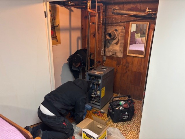 Skilled Parrish Services technicians perform thorough furnace maintenance in tight spaces, ensuring safe reliable heating for your home.