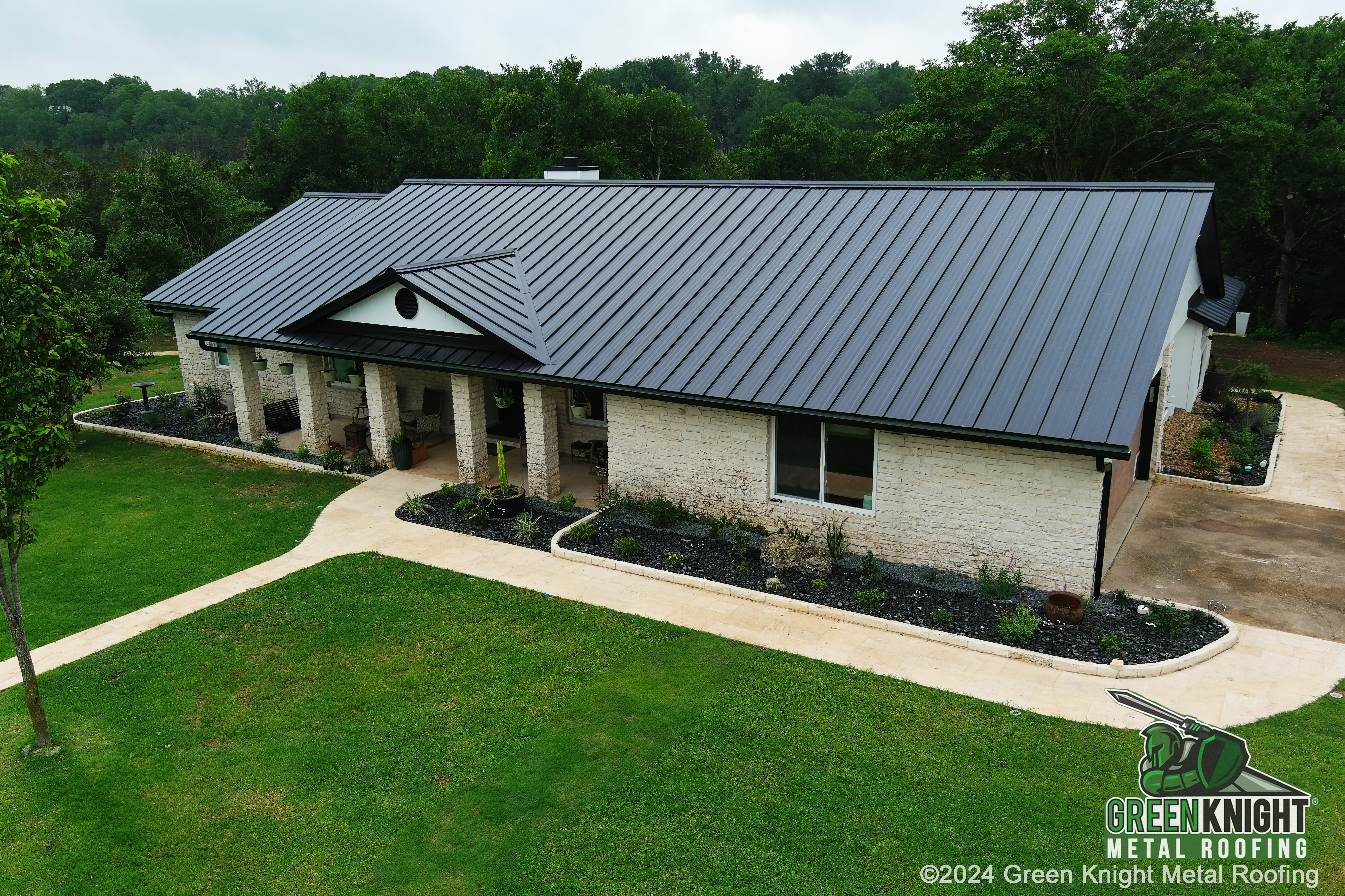 Green Knight® Metal Roofing showcases a superior metal roofing solution that seamlessly integrates with the beauty of nature, enhancing this beautiful home's curb appeal.