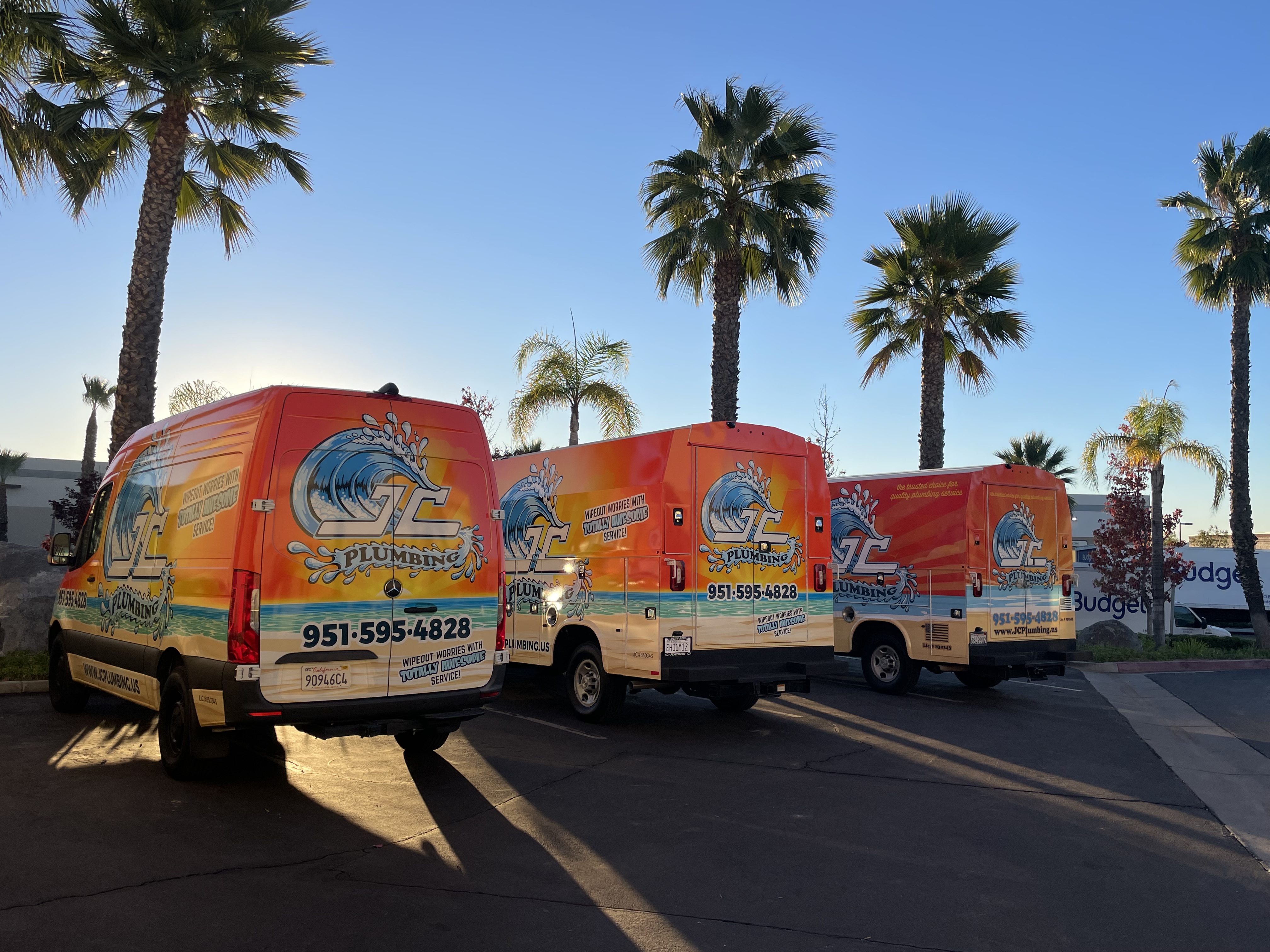 JC Plumbing's fleet of vibrant, well-branded service vans showcases our commitment to quality and professionalism, ready to serve you under the sunny skies.