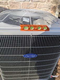 Careful installation and inspection give homeowners confidence, shown here by a level check on a Carrier unit by Cardinal Plumbing Heating & Air Inc.
