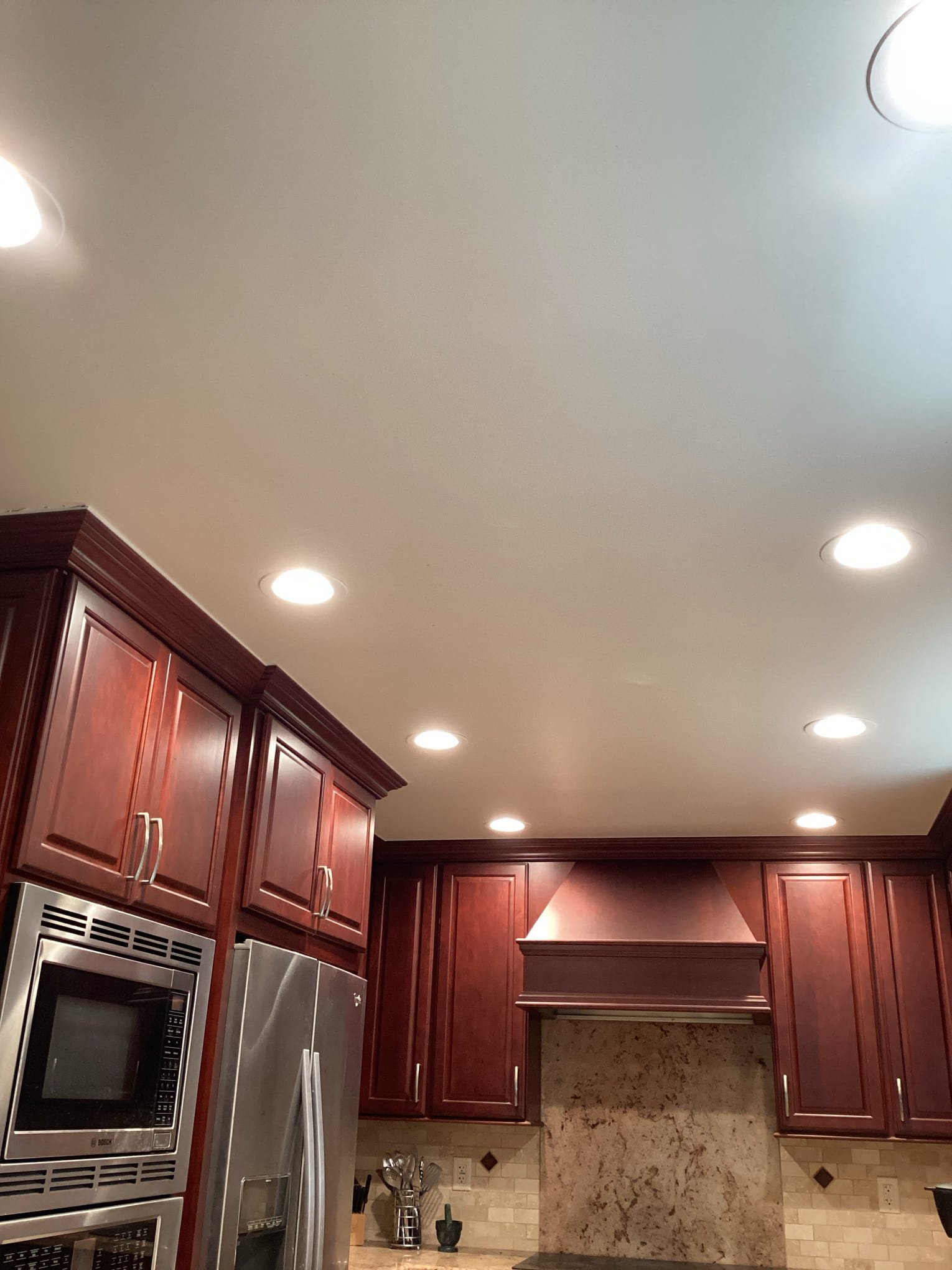 Bright, evenly spaced recessed lighting highlights craftsmanship and safety in this kitchen, proudly installed by Powell Electric.