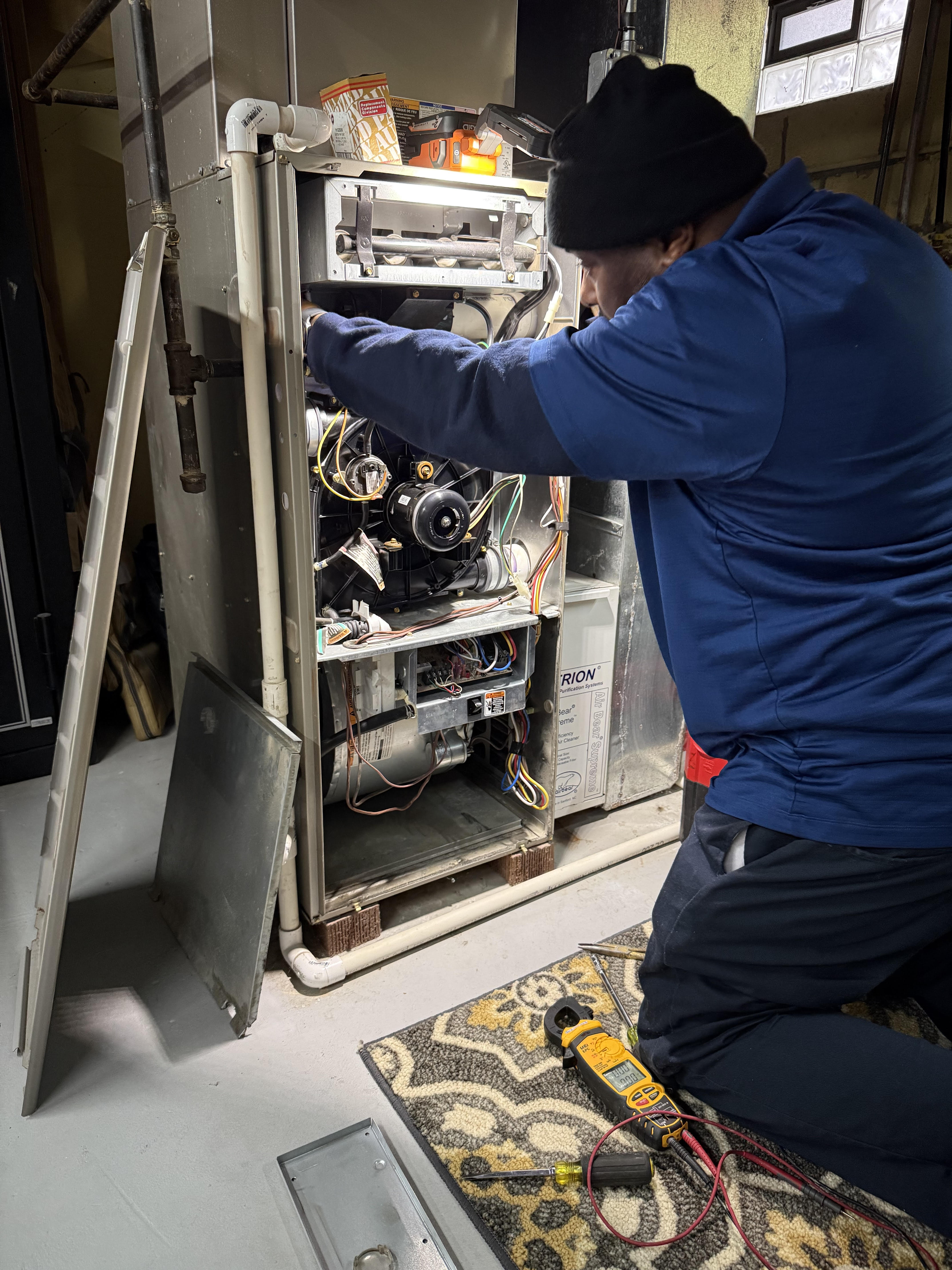 A Windy City HVAC Repair technician performs careful diagnostic work on a home furnace, showcasing reliable, professional service.