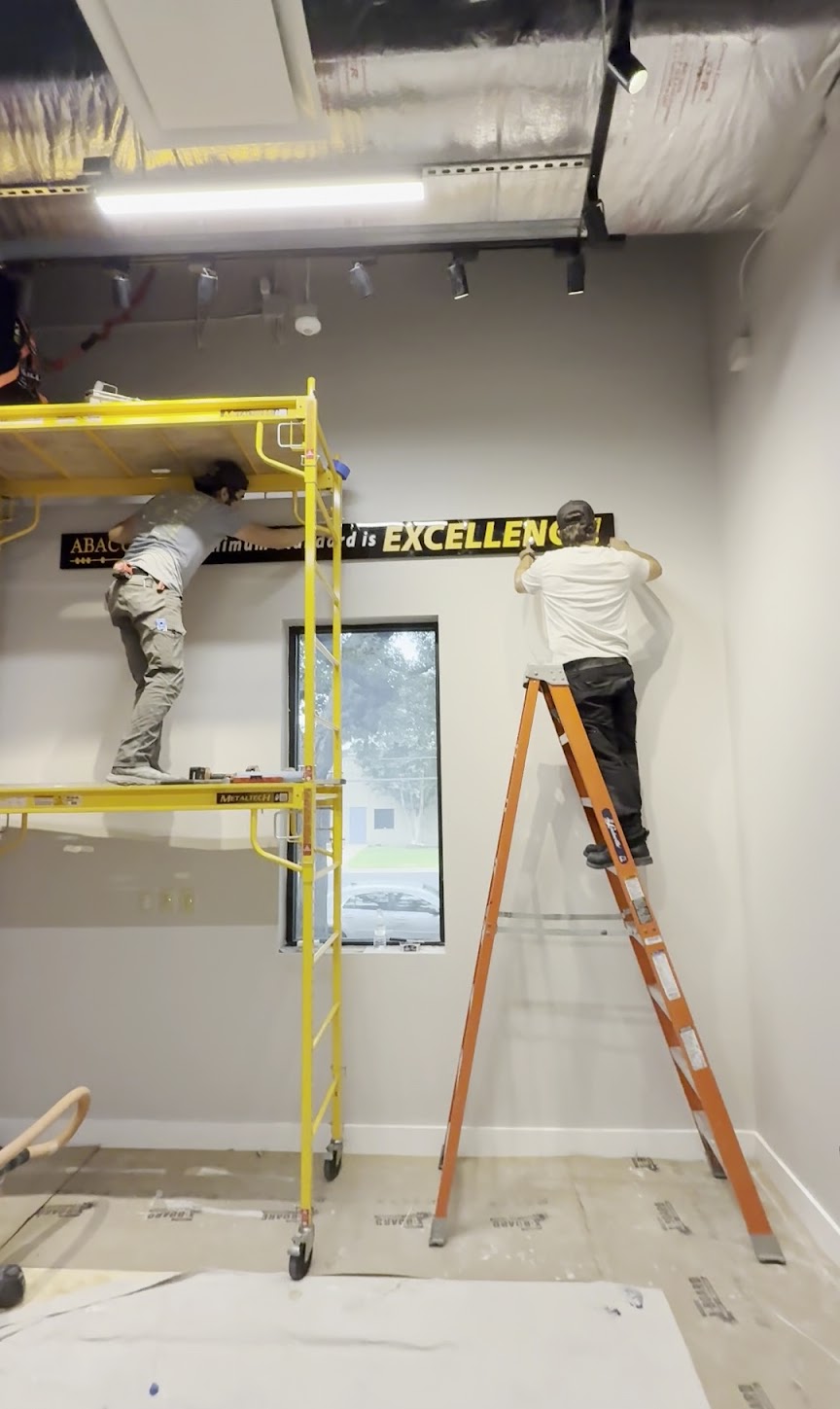 Putting craftsmanship on display, Abacus Plumbing, Air Conditioning, & Electrical installs a branded interior sign to showcase attention to detail.