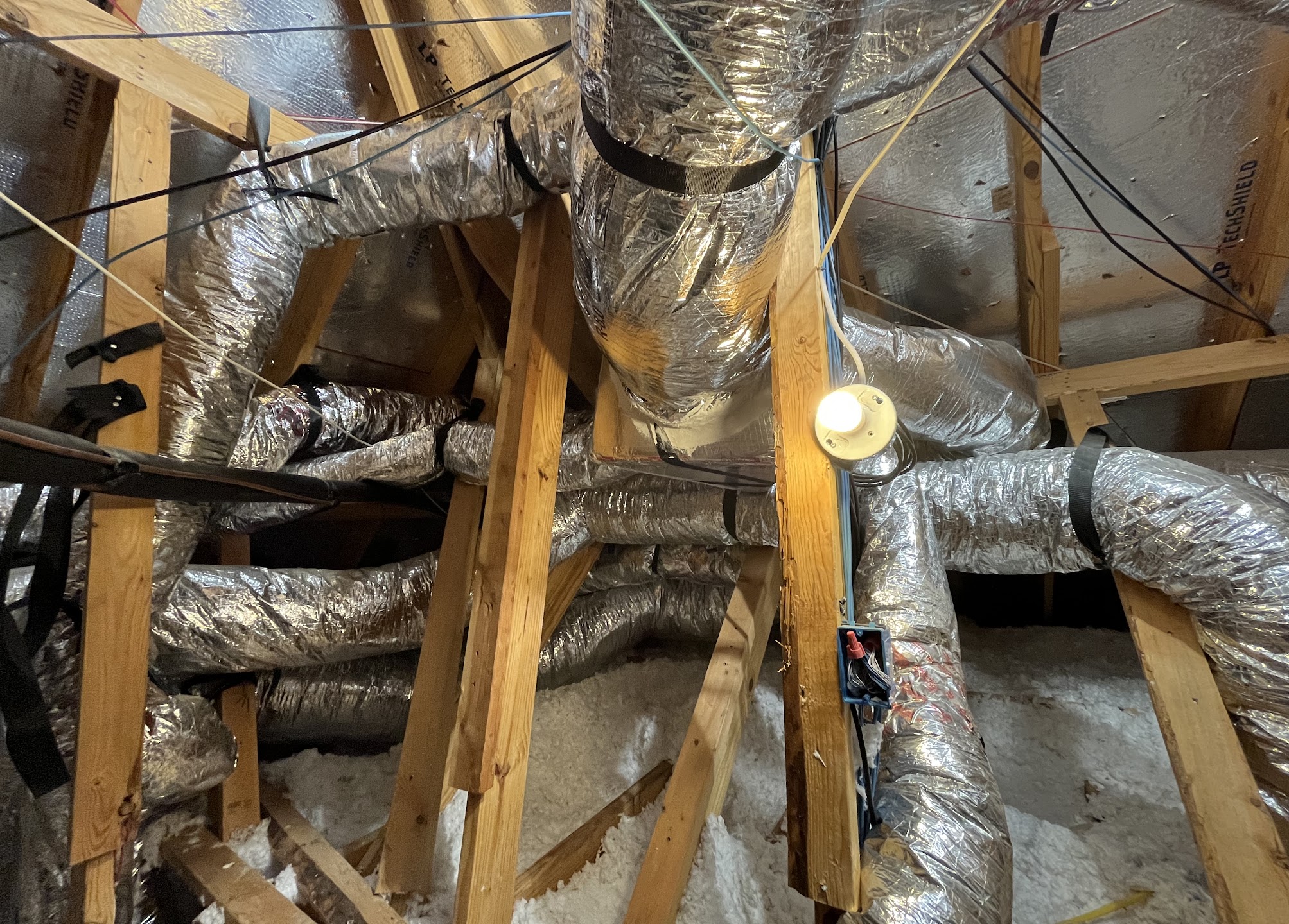 Neat attic ductwork and energy-efficient insulation demonstrate the careful craftsmanship homeowners expect from Abacus Plumbing, Air Conditioning & Electrical.