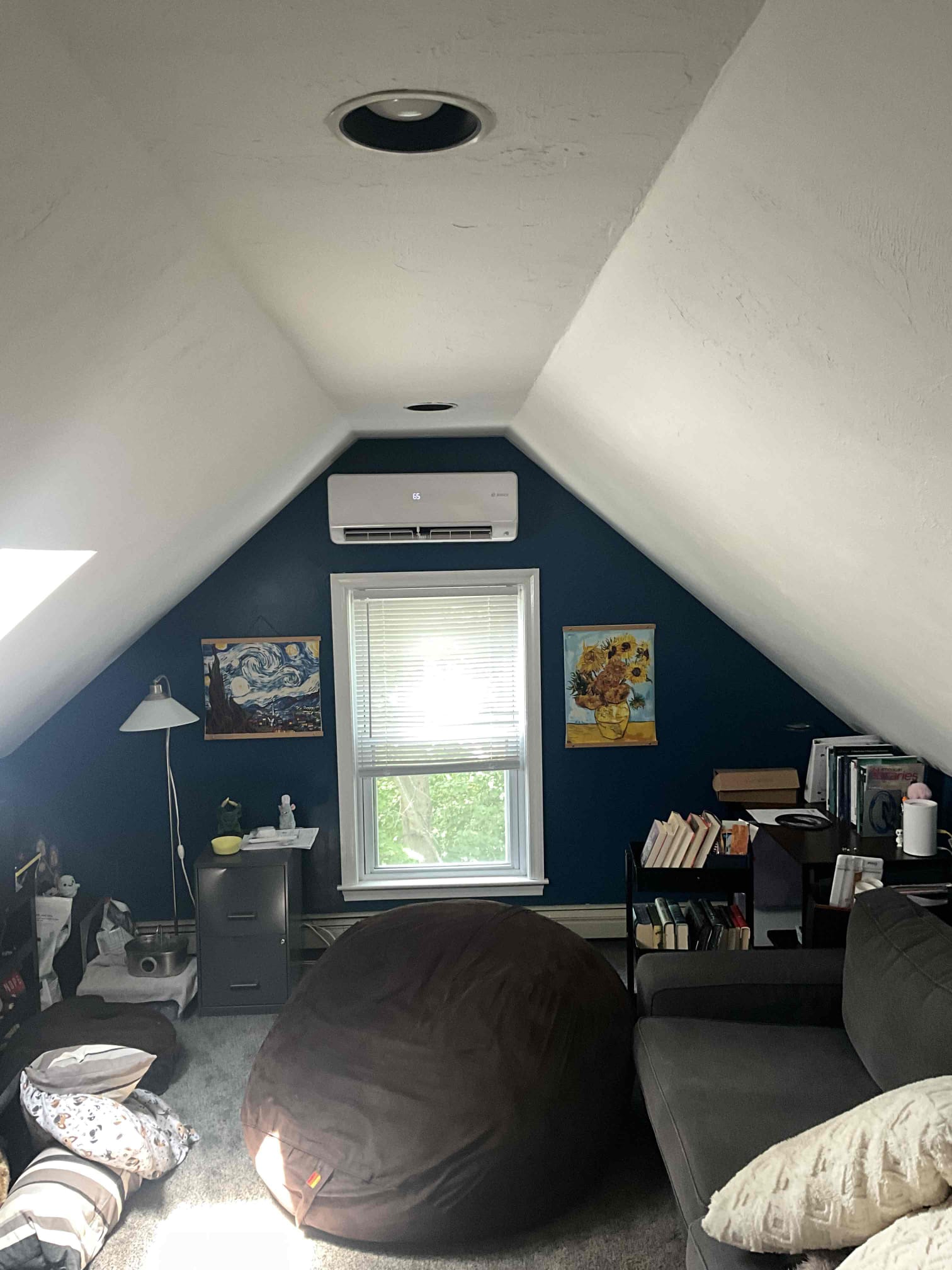 A neat wall-mounted ductless mini-split keeps this cozy loft comfortable, showcasing Akian Plumbing, Heating, Cooling & Electric’s attentive installation.