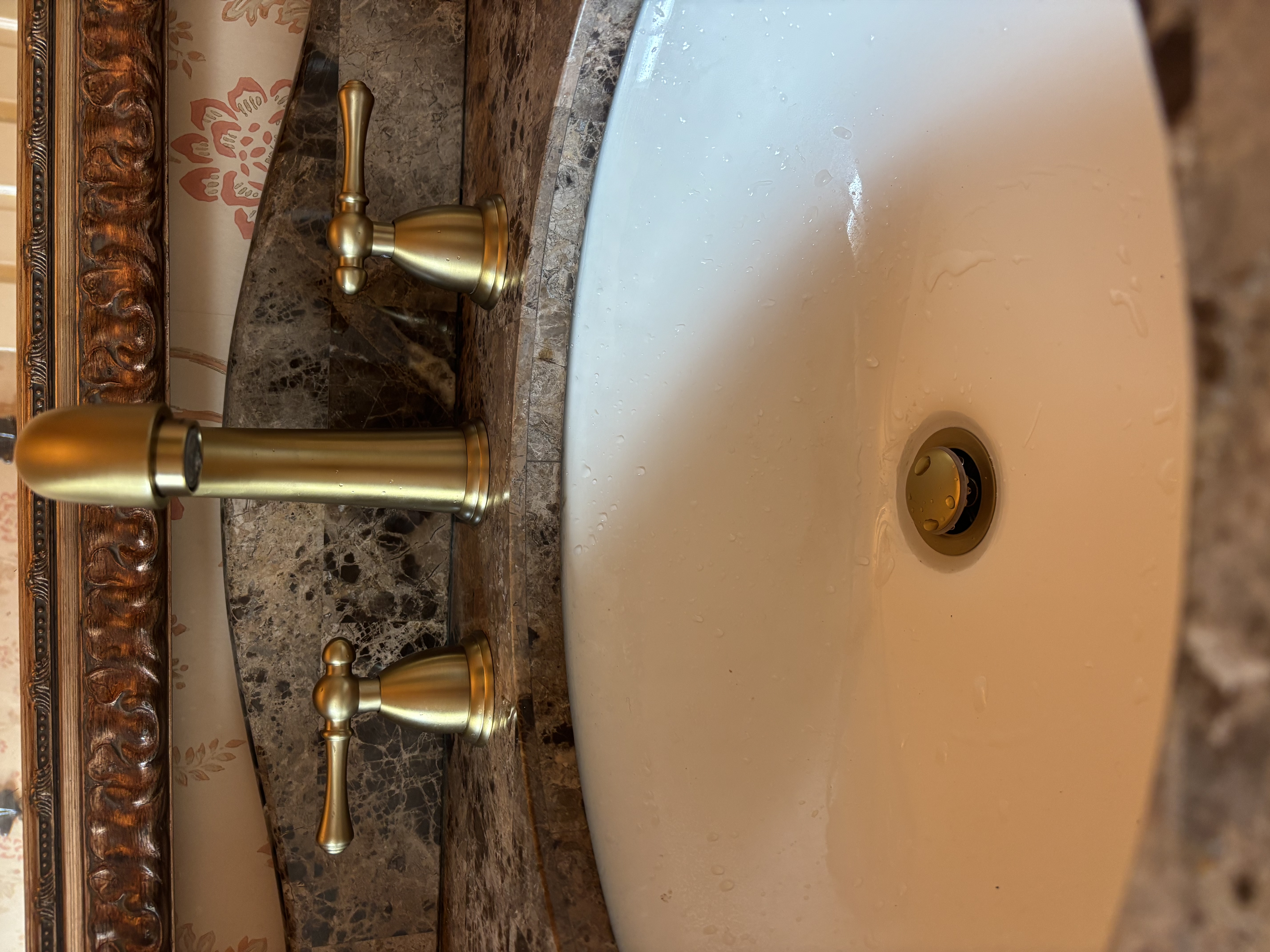 Island Plumbing installed and finished this elegant gold faucet with careful attention to fit and polishing for a refined bathroom look.