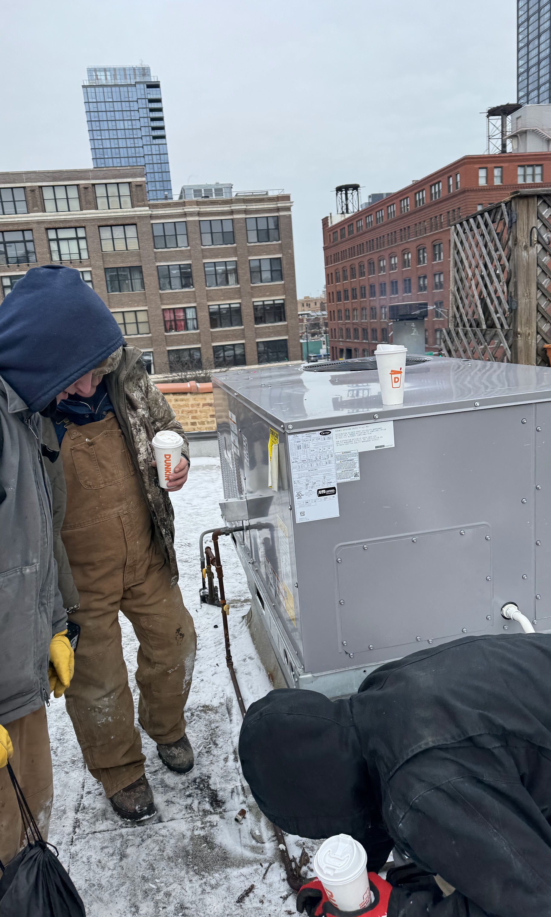 Working in harsh winter weather, Oasis Heating and Cooling demonstrates dependable rooftop HVAC service with attentive, safety-minded technicians.