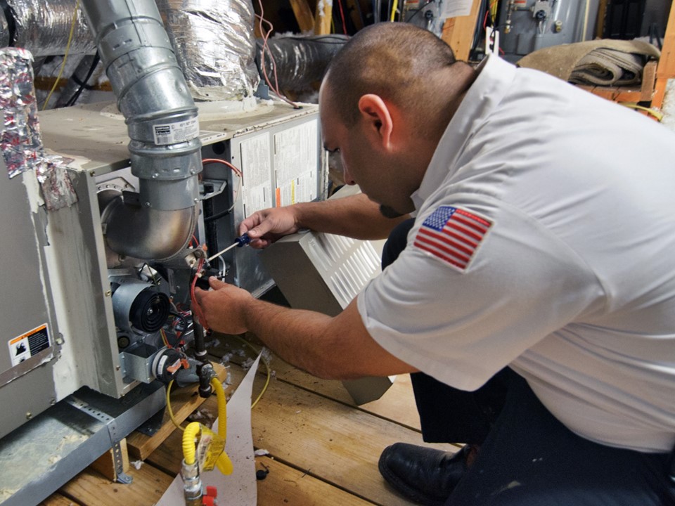 A skilled technician from Abacus Plumbing, Air Conditioning & Electrical carefully services a furnace to ensure safe, reliable heating for your home.