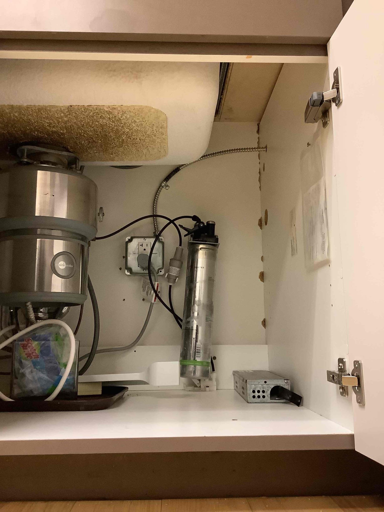Powell Electric inspected the under-sink wiring and disposal setup to identify safety risks and recommend tidy, code-compliant fixes.