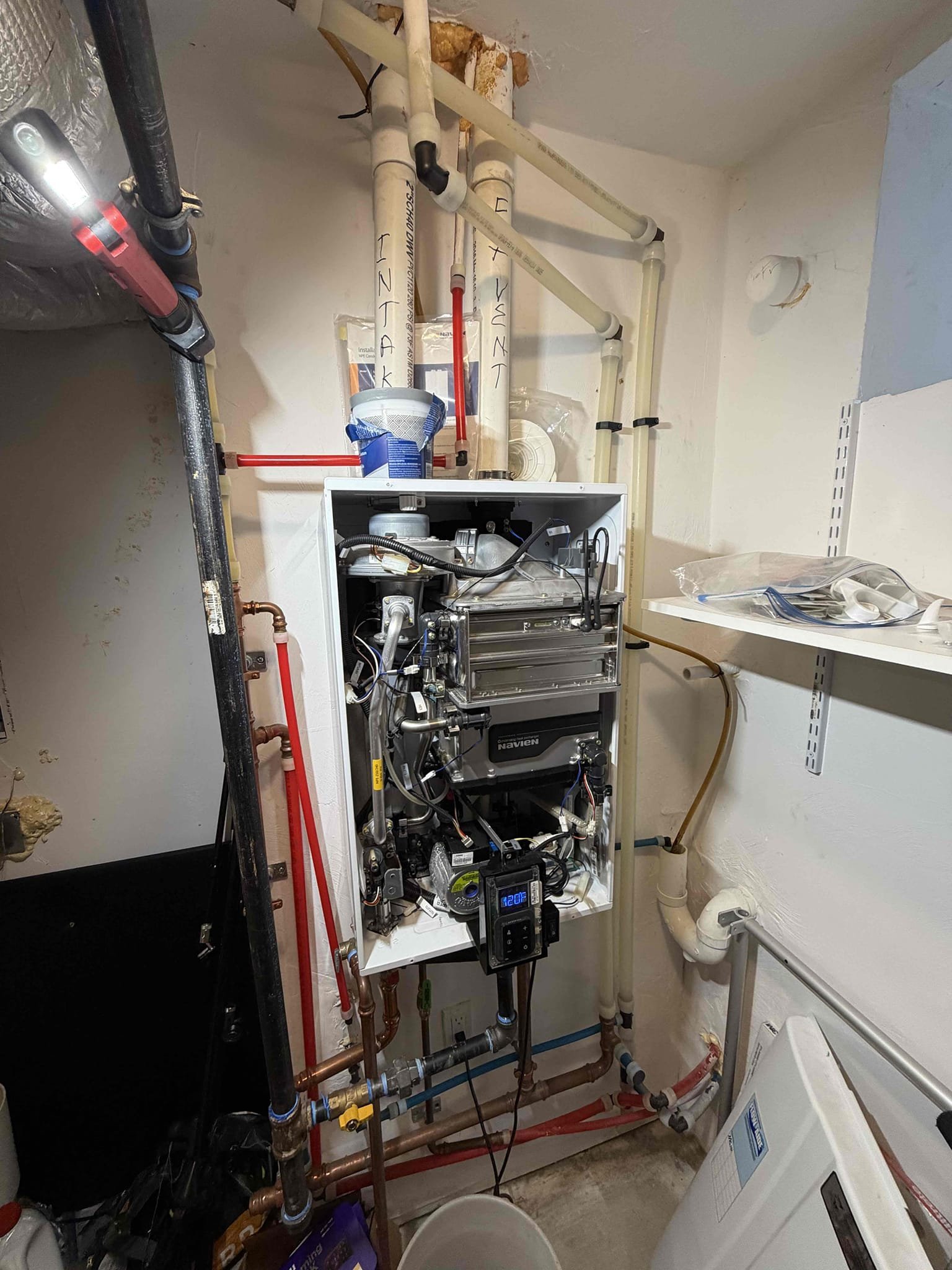 Akian Plumbing, Heating, Cooling & Electric demonstrates careful, professional maintenance on a tankless system to ensure reliable home comfort.