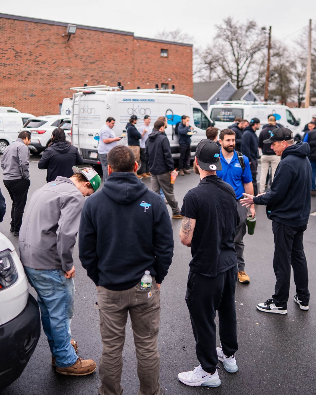 A skilled, approachable team gathers in the field, showcasing Akian Plumbing, Heating, Cooling & Electric's reliable local service and teamwork.