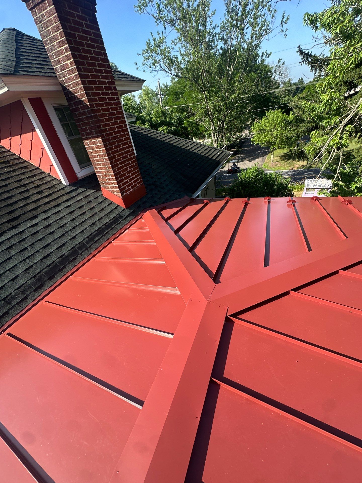 A precision-installed red metal roof showcases lasting durability and craftsmanship from Mast Roofing & Construction, enhancing curb appeal and protection.