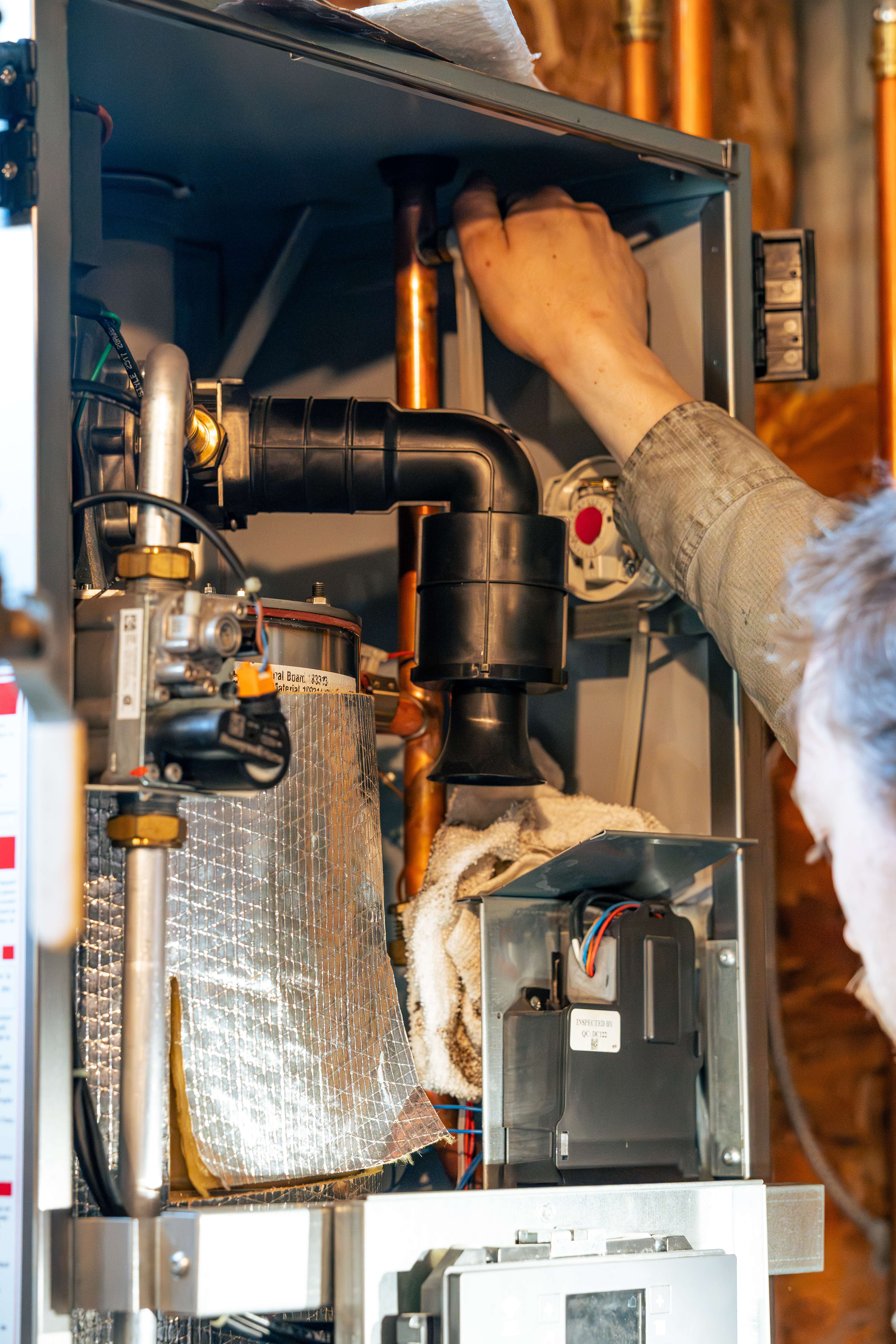 A skilled technician from Lloyd Plumbing, Heating, Air, Electrical adjusts internal HVAC components to ensure safe, reliable heating performance.