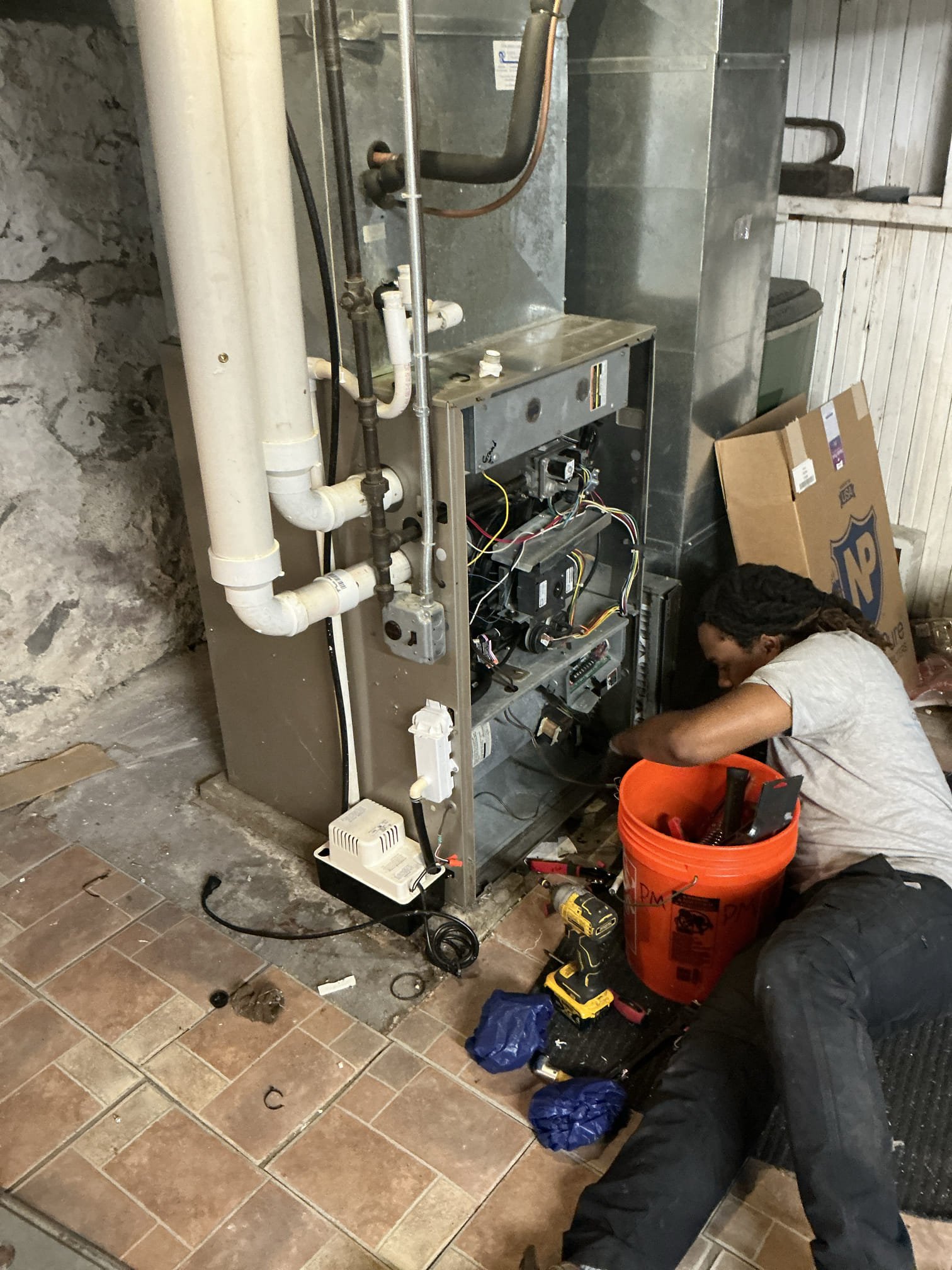 A skilled technician from Akian Plumbing, Heating, Cooling & Electric performs careful furnace maintenance, demonstrating dependable craftsmanship and attention to detail.