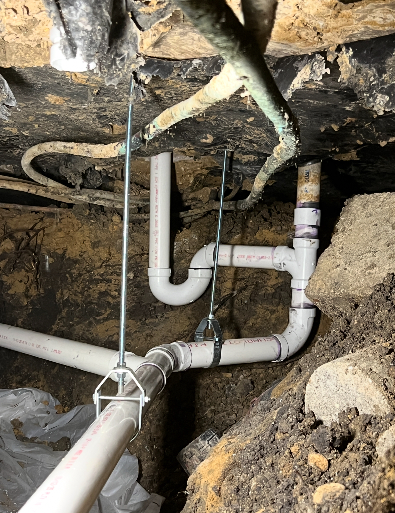 Reliable drain replacement in a tight crawlspace shows Rise Plumbing Systems delivering durable, cleanly installed PVC drainage with care.