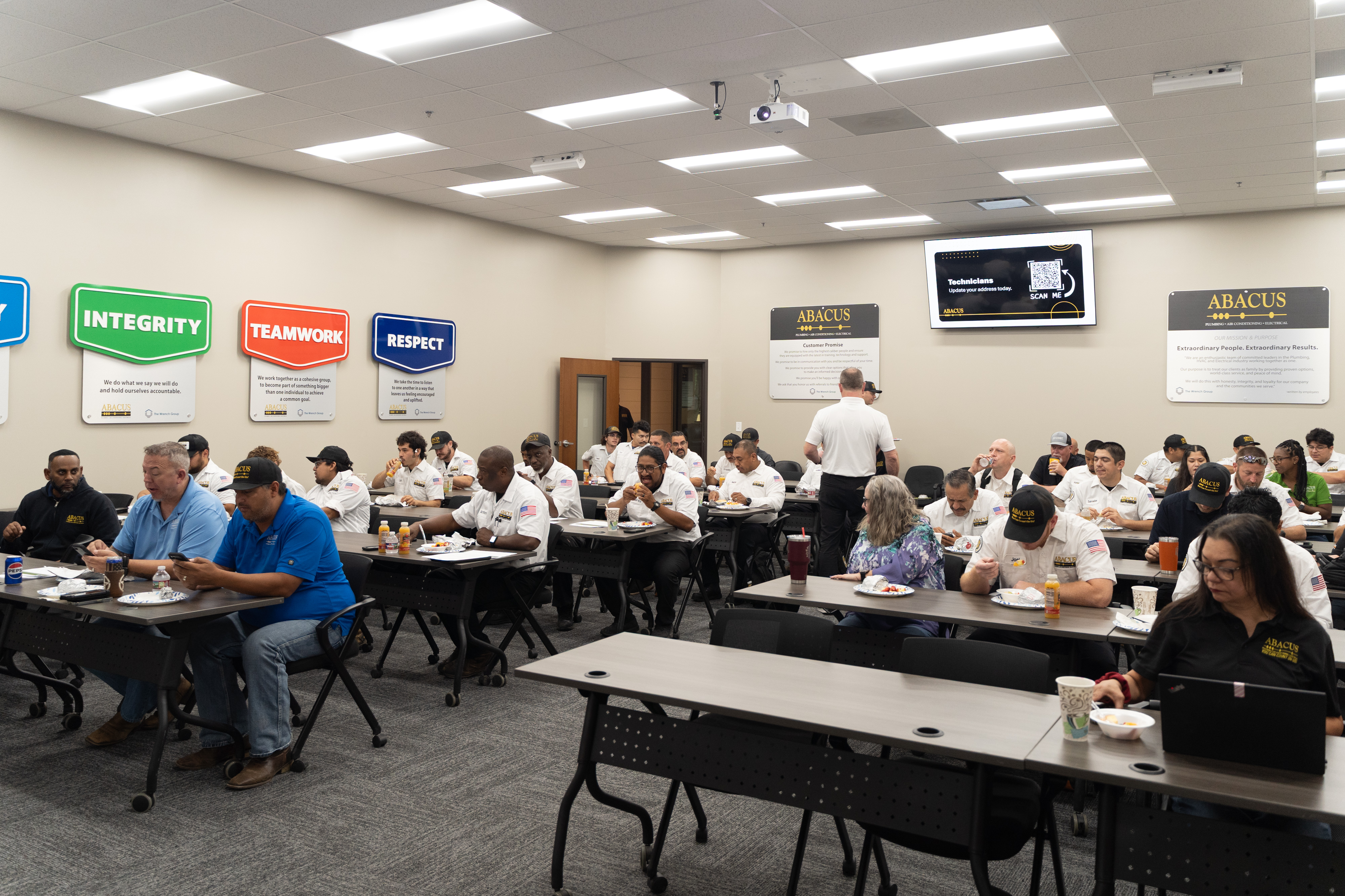 Abacus Plumbing, Air Conditioning, & Electrical showcases a professional team training together, reinforcing trust and consistent service standards.