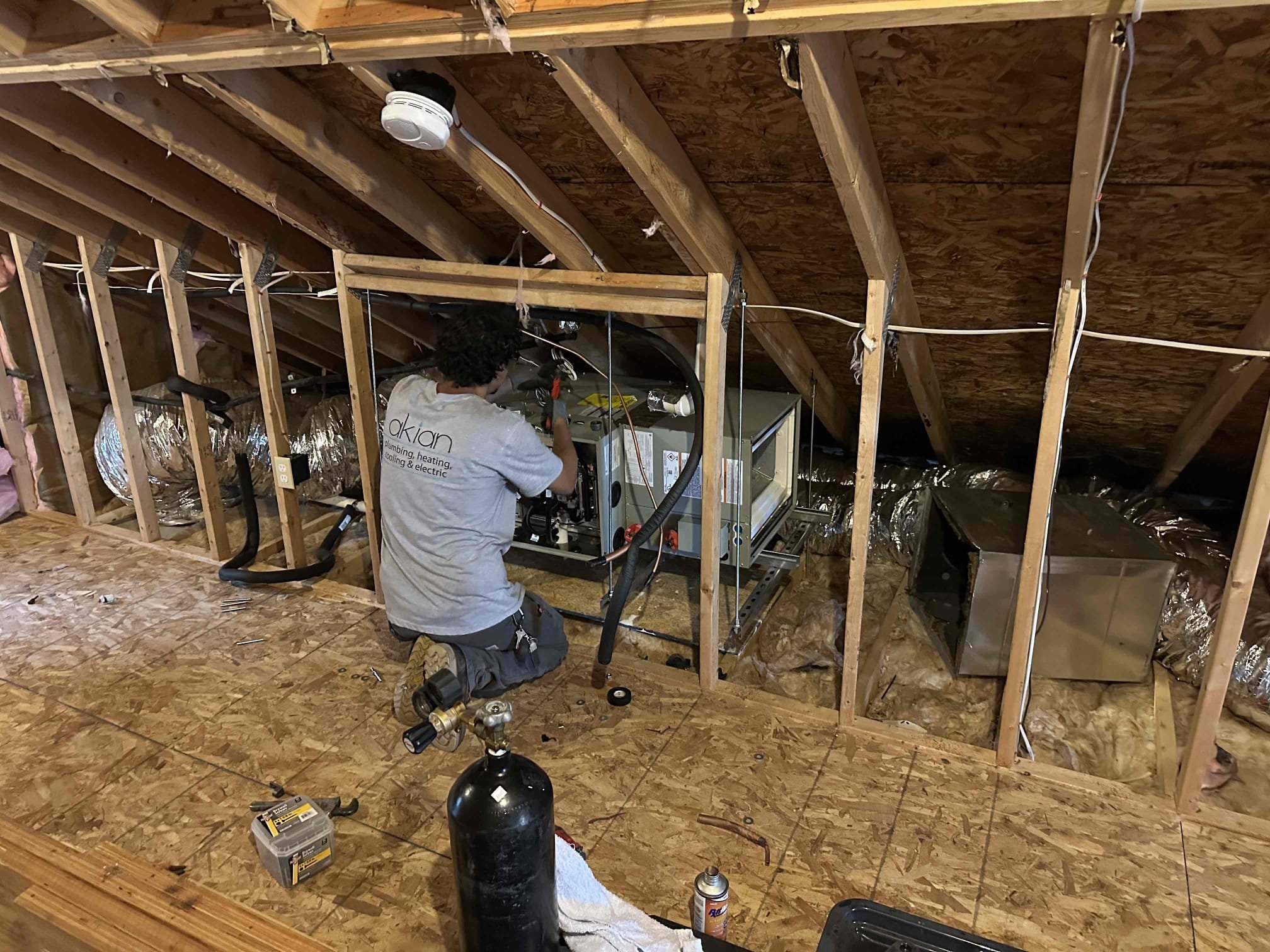 Skilled technicians from Akian Plumbing, Heating, Cooling & Electric carefully service attic HVAC systems to ensure dependable home comfort.