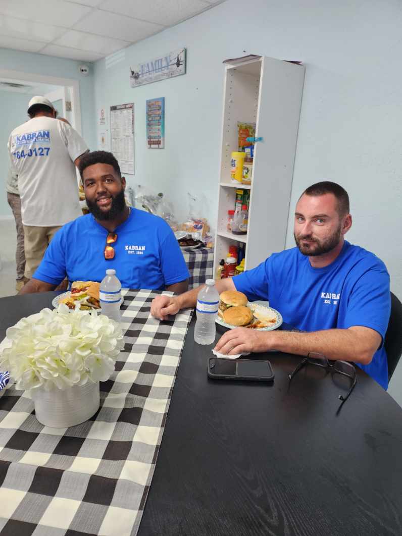 Enjoying a moment of camaraderie and great food at Kabran Air Conditioning & Heating, where quality and teamwork meet.