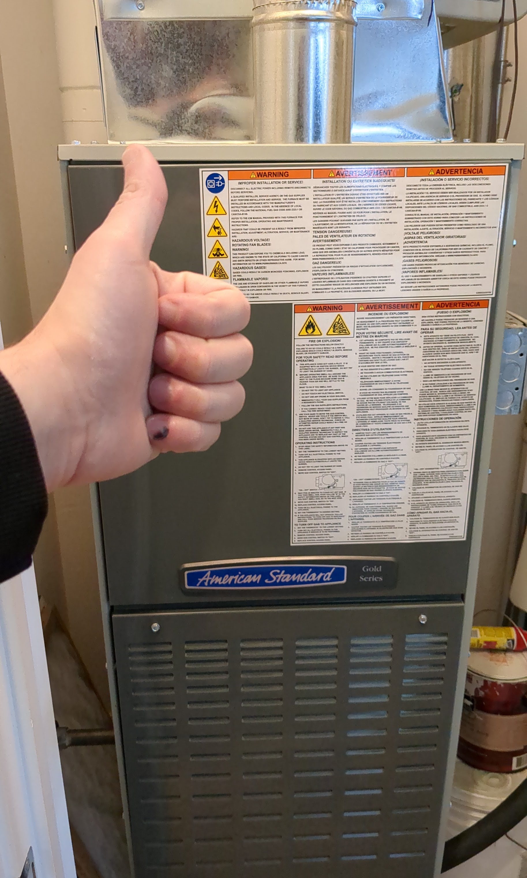 A satisfied thumbs-up after a reliable furnace service shows the care and safety Oasis Heating and Cooling brings to every home visit.