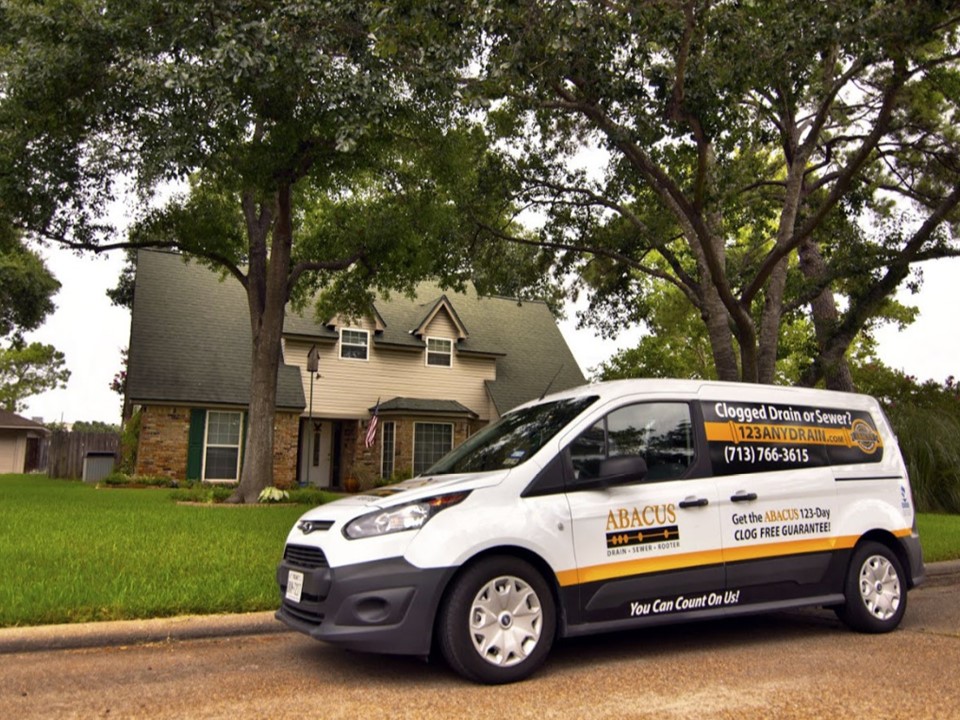 A clean, branded service van parked at a homeowner's property shows Abacus Plumbing, Air Conditioning & Electrical ready to deliver reliable, customer-focused service.