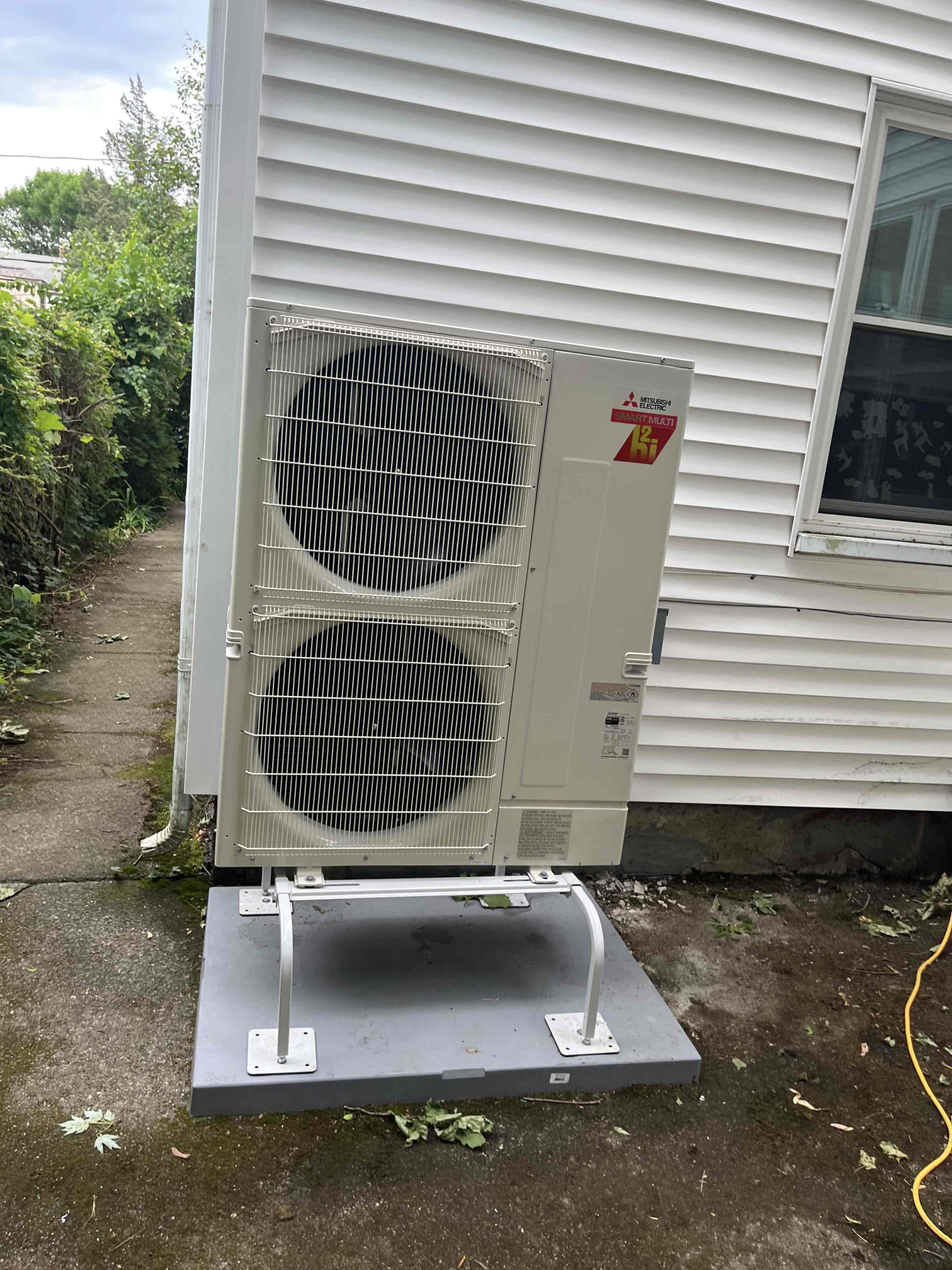 A precise, neat installation of a Mitsubishi outdoor unit shows the craftsmanship customers trust from Akian Plumbing, Heating, Cooling & Electric.